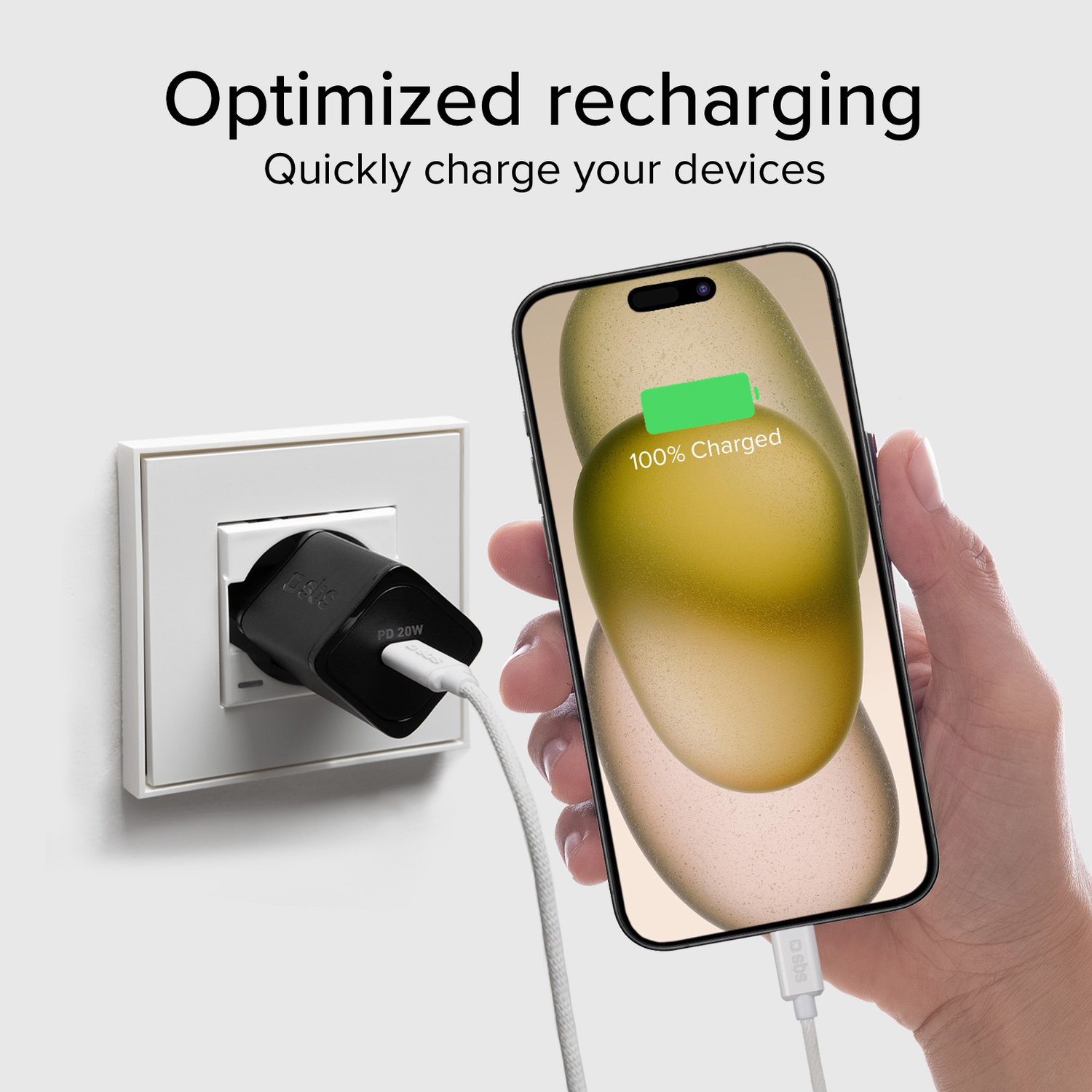 Téléphone en charge, 100% chargé, chargeur noir, fond blanc.
