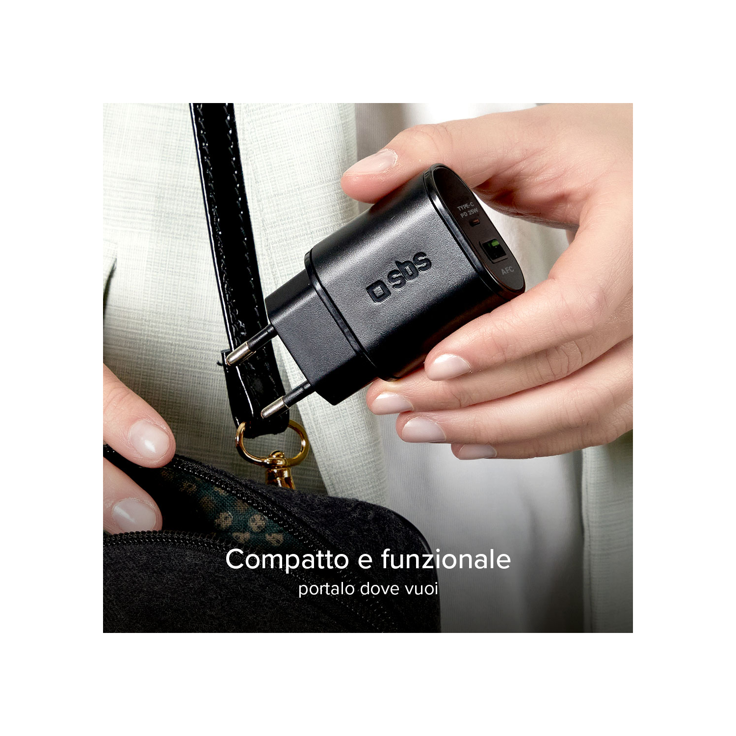 Een hand die een zwarte oplader vasthoudt. Tekst: Compact en functioneel, neem hem overal mee naartoe.