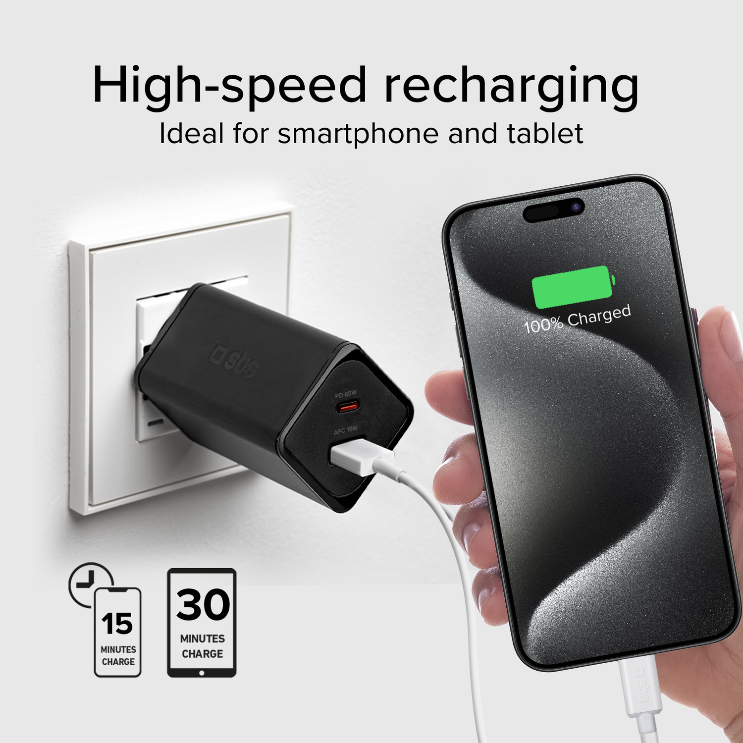 A phone charging with a black charger plugged into a wall, displaying 100% charged.