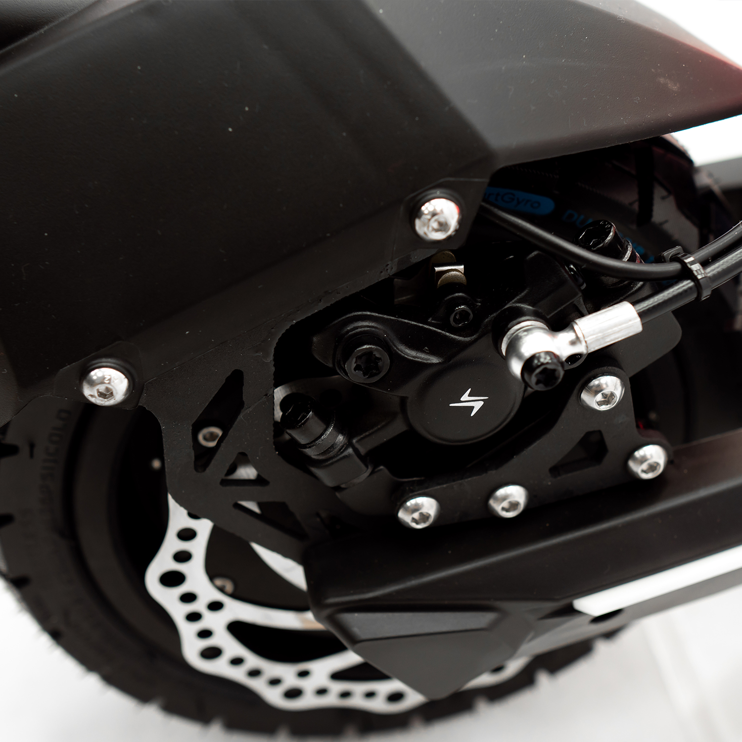 Primer plano de la rueda de un scooter con freno negro y componentes plateados.