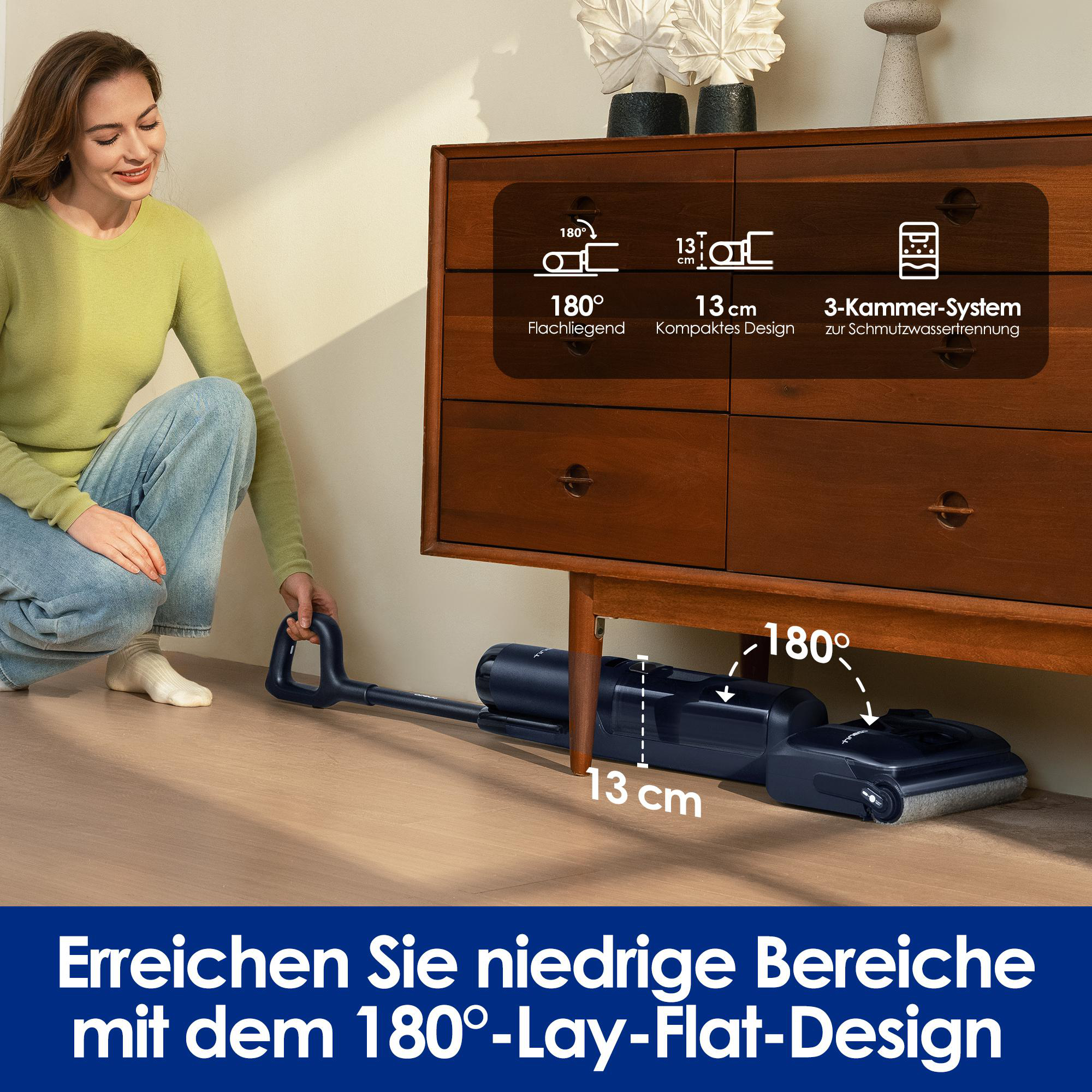 Frau benutzt Staubsauger. Staubsauger ist schwarz, der Boden ist Holz, und die Frau trägt ein grünes Hemd.