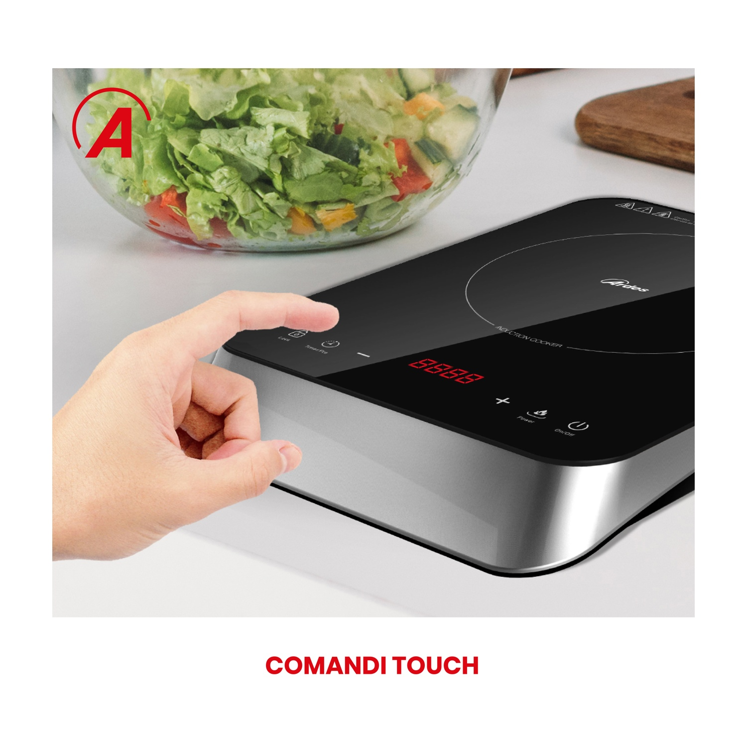 Piano cottura a induzione con mano che tocca il pannello touch, insalata sullo sfondo.