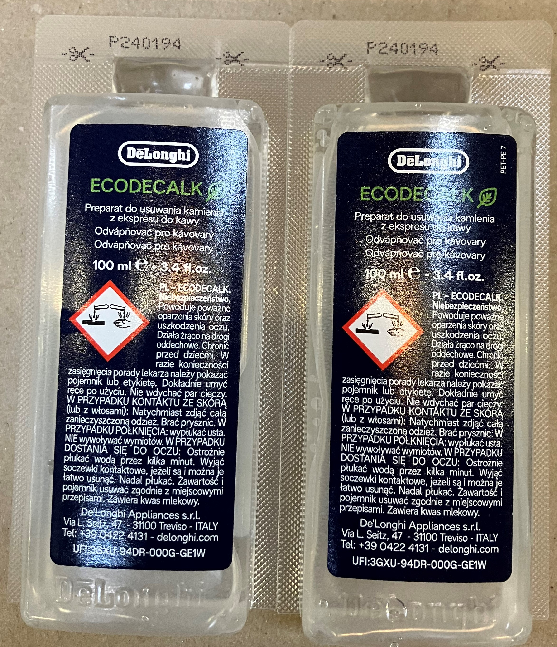 Dwie butelki Delonghi Ecodecalk z instrukcjami w wielu językach.