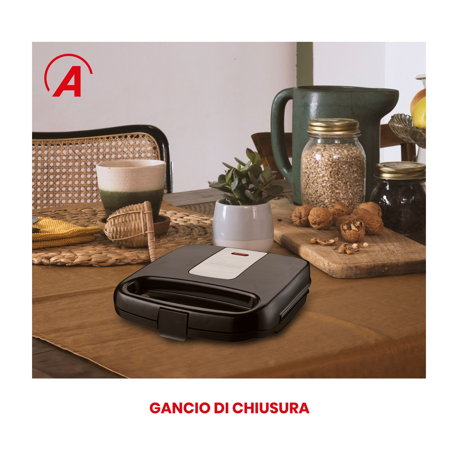 Macchina per sandwich nera su un tavolo marrone, con altri articoli da cucina.