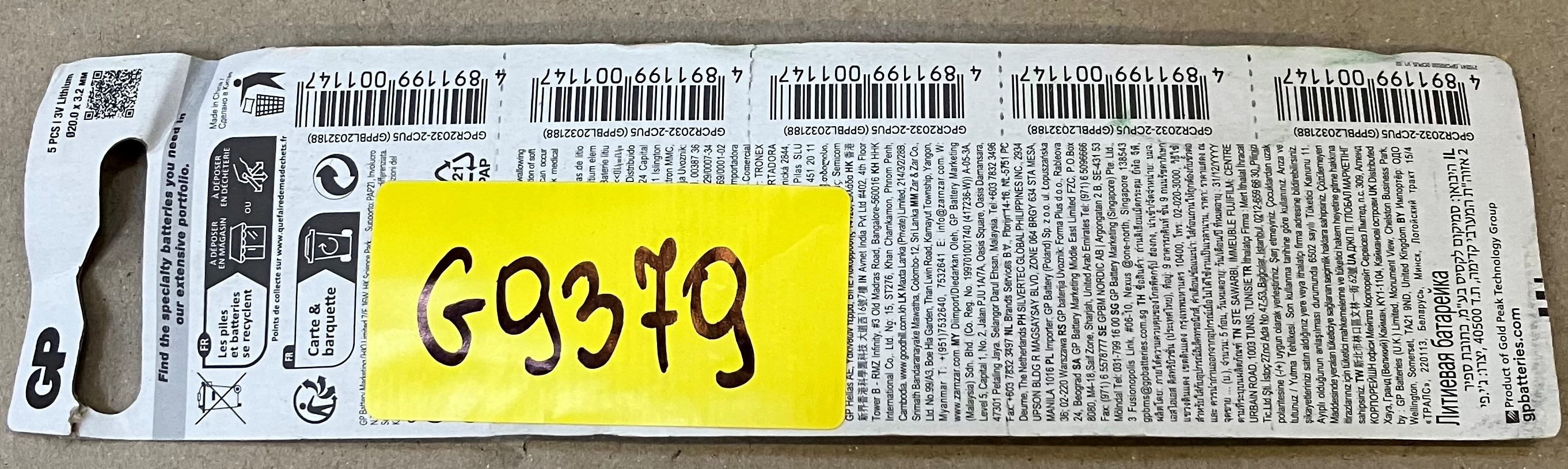 Opakowanie baterii z kodami kreskowymi i żółtą naklejką z napisem 'G9379'.