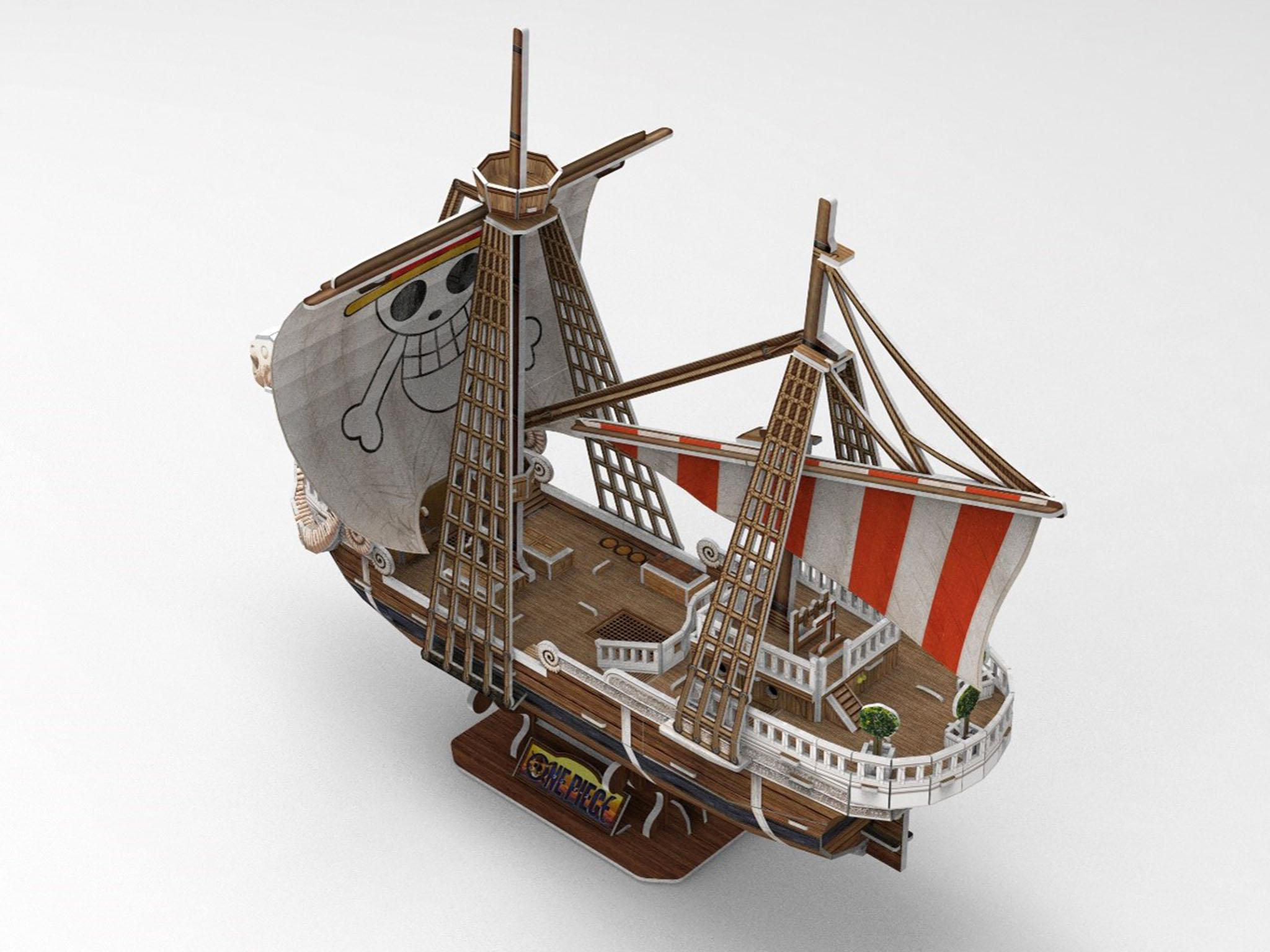 Ein Holzmodell eines Schiffs mit Segeln und einer Totenkopfflagge.