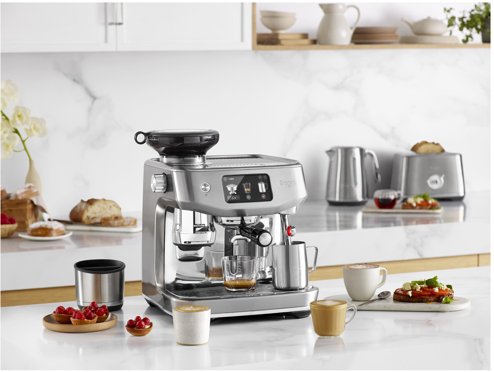 Espresszó gép kávéval, csészékkel és kiegészítőkkel a konyhapulton.