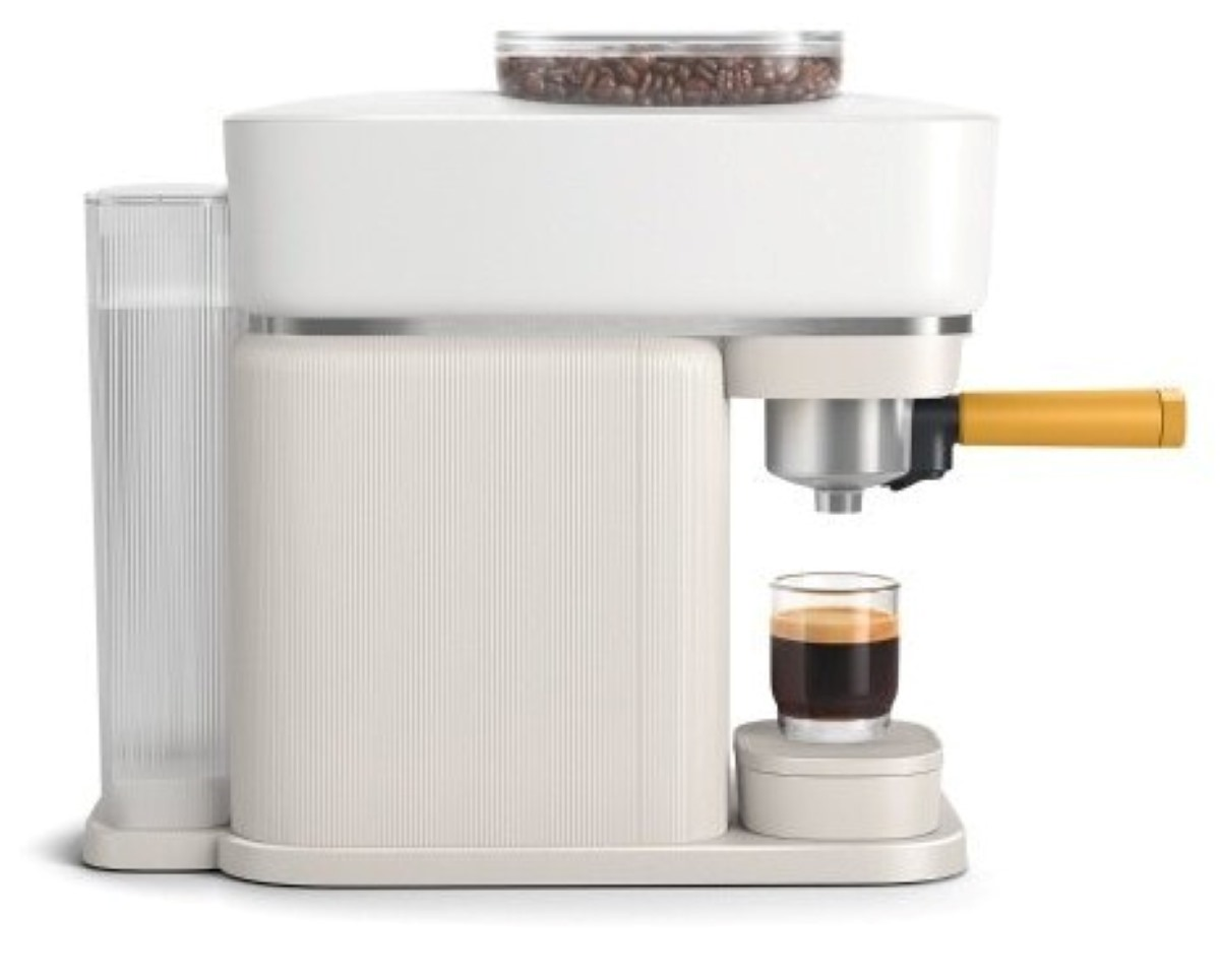 Biało-kremowy ekspres do kawy ze szklanką kawy.