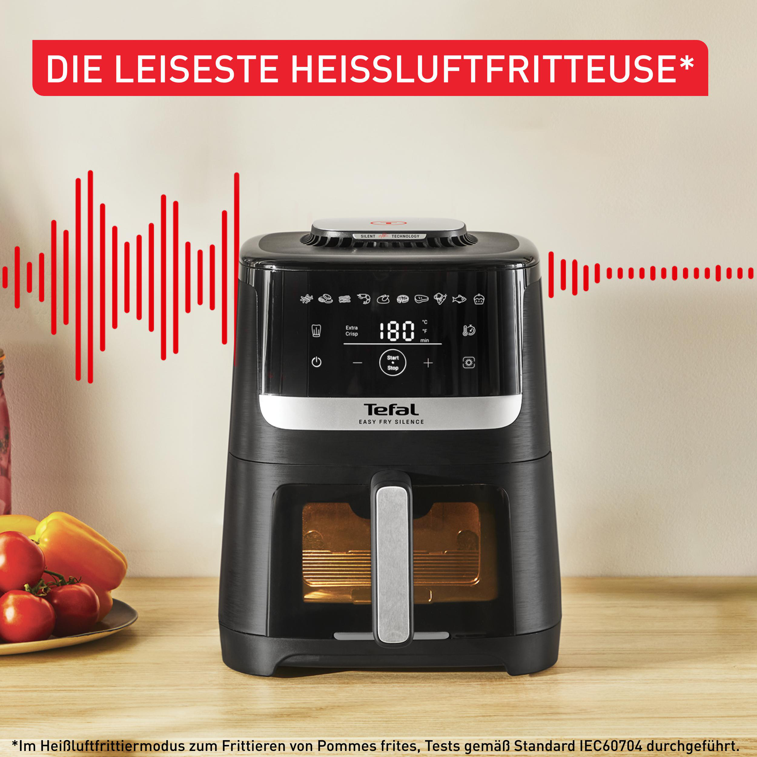 Schwarze Heißluftfritteuse mit Digitalanzeige, roten Schallwellen und Text auf Deutsch.