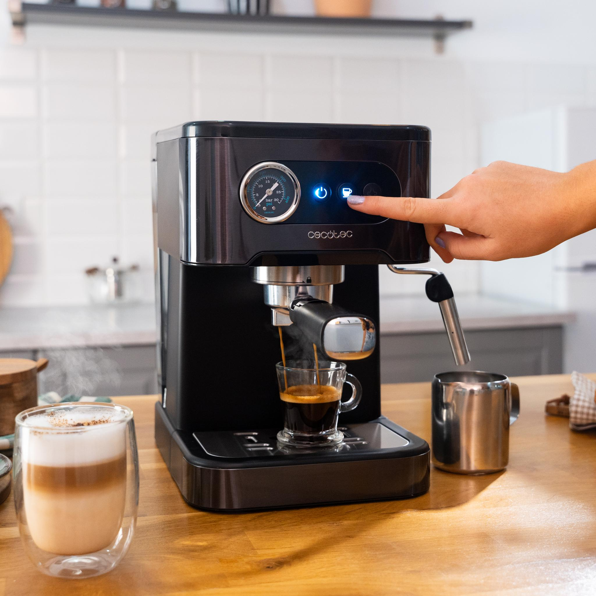 Máquina de café con un vaso de café haciéndose, mano presionando un botón.