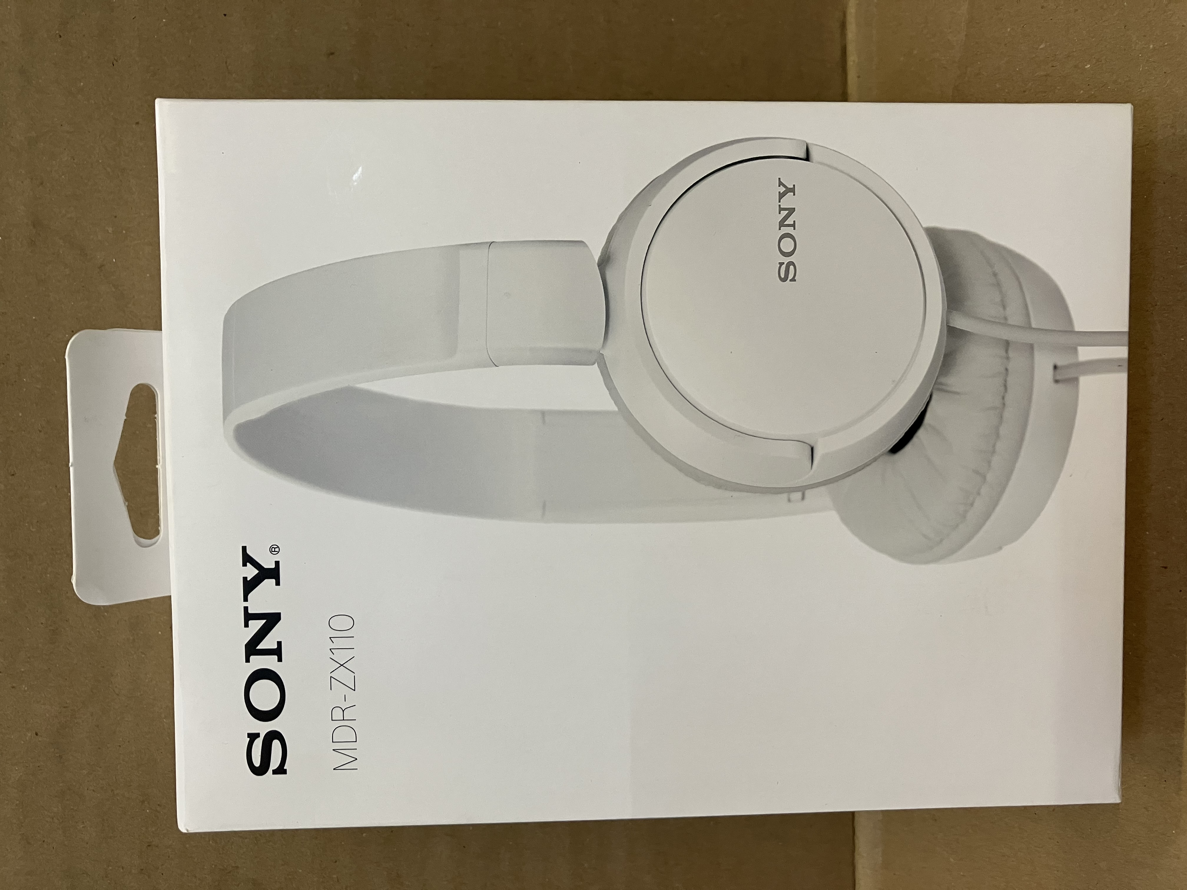 Białe pudełko słuchawek z napisem SONY.