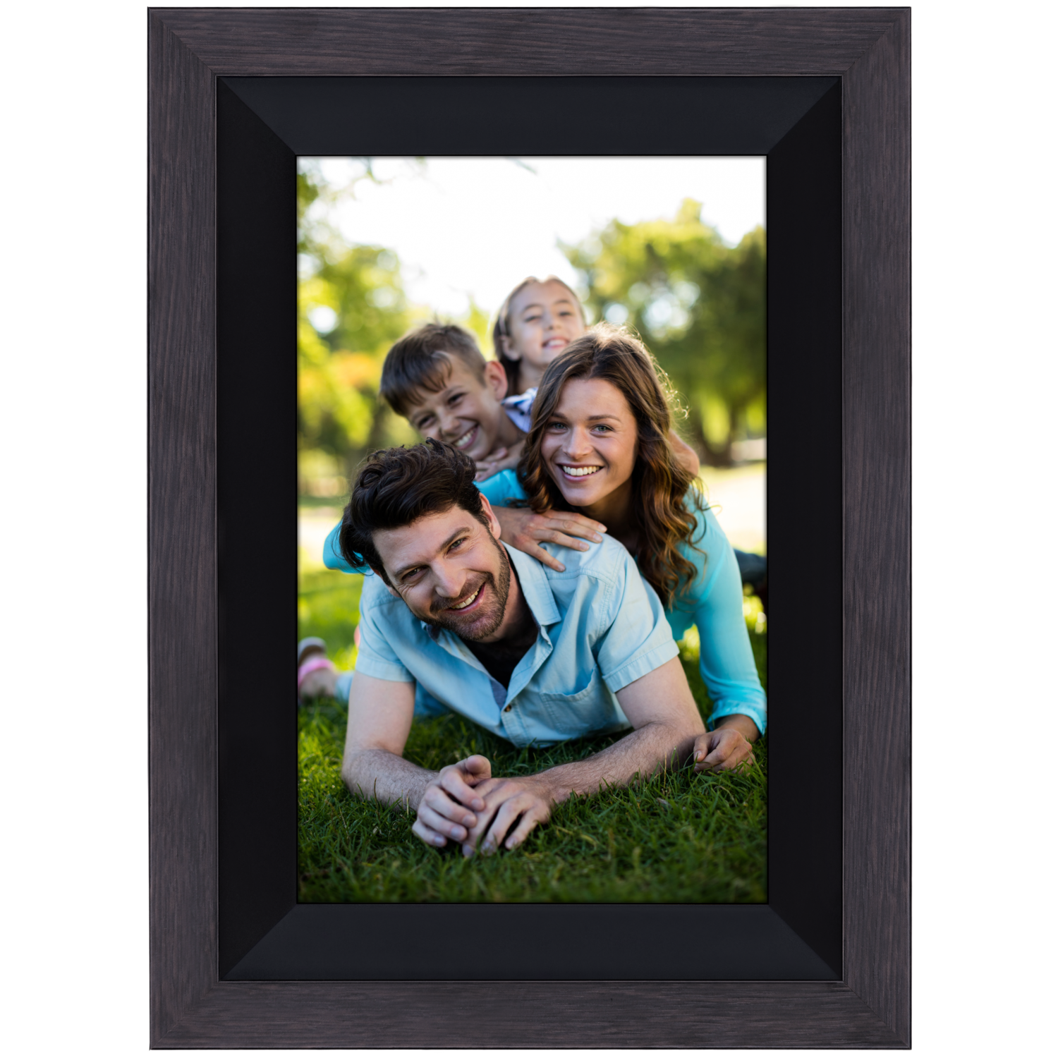 Family in a frame on grass. Parents and children smiling, in a dark frame.