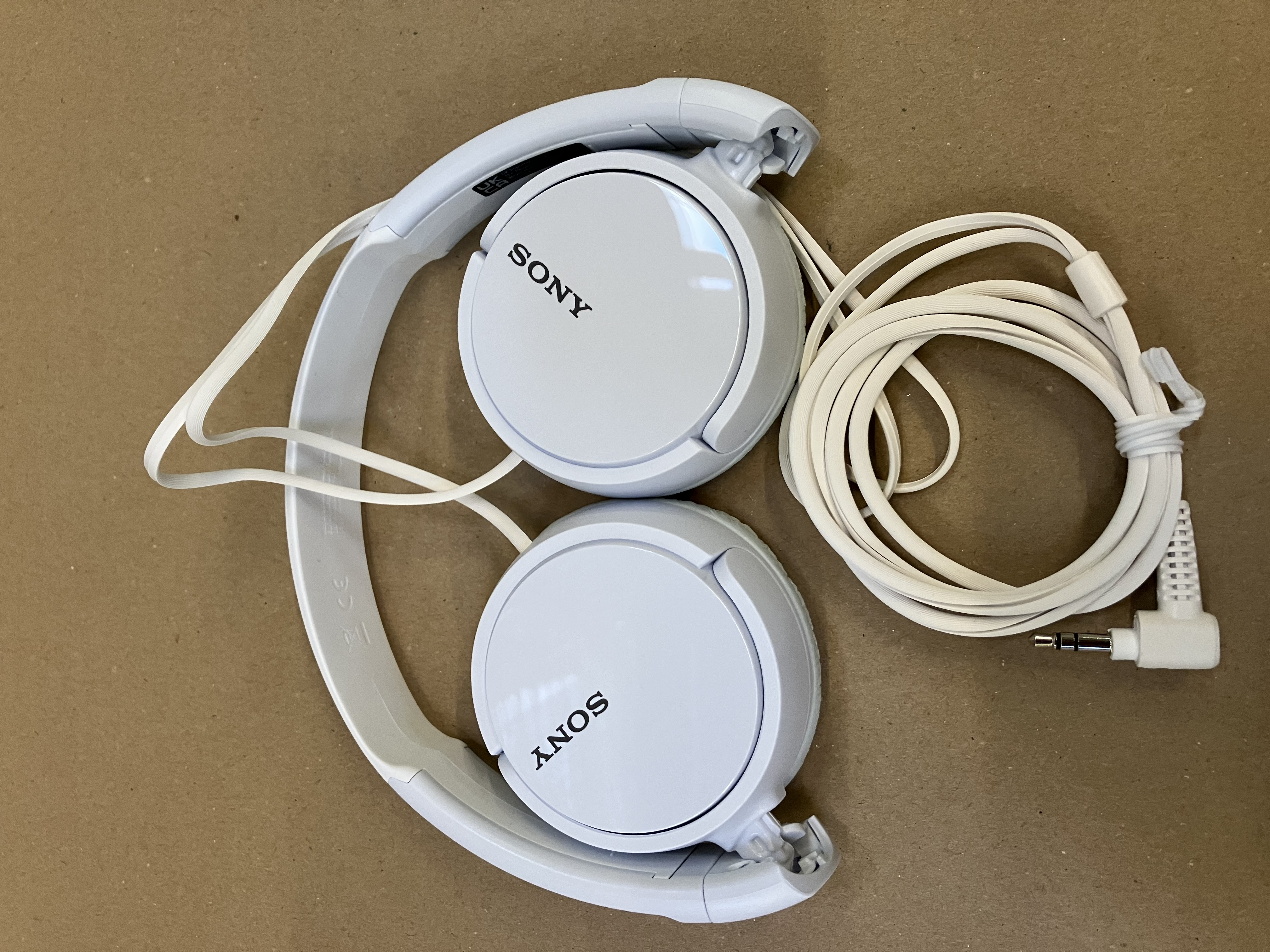 Biały ceramiczny słoik z drewnianą pokrywką, ma wzór twarzy.