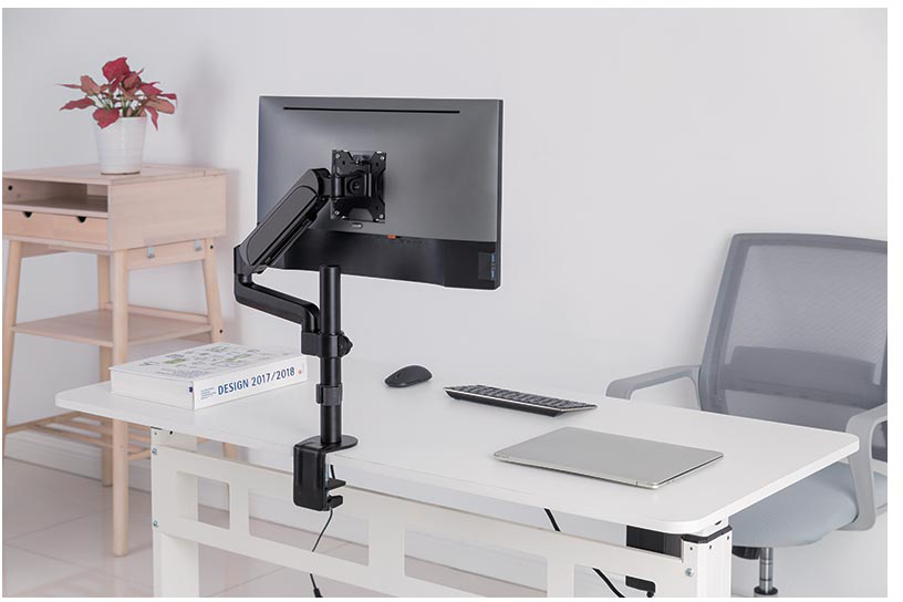 Egy asztali beállítás, egy monitorral állványon, billentyűzettel, egérrel és egy laptop-pal.