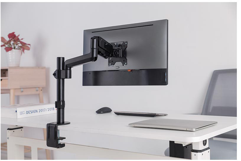 Egy számítógép monitor egy asztalra szerelve állvánnyal. Egy laptop és egy egér az asztalon.