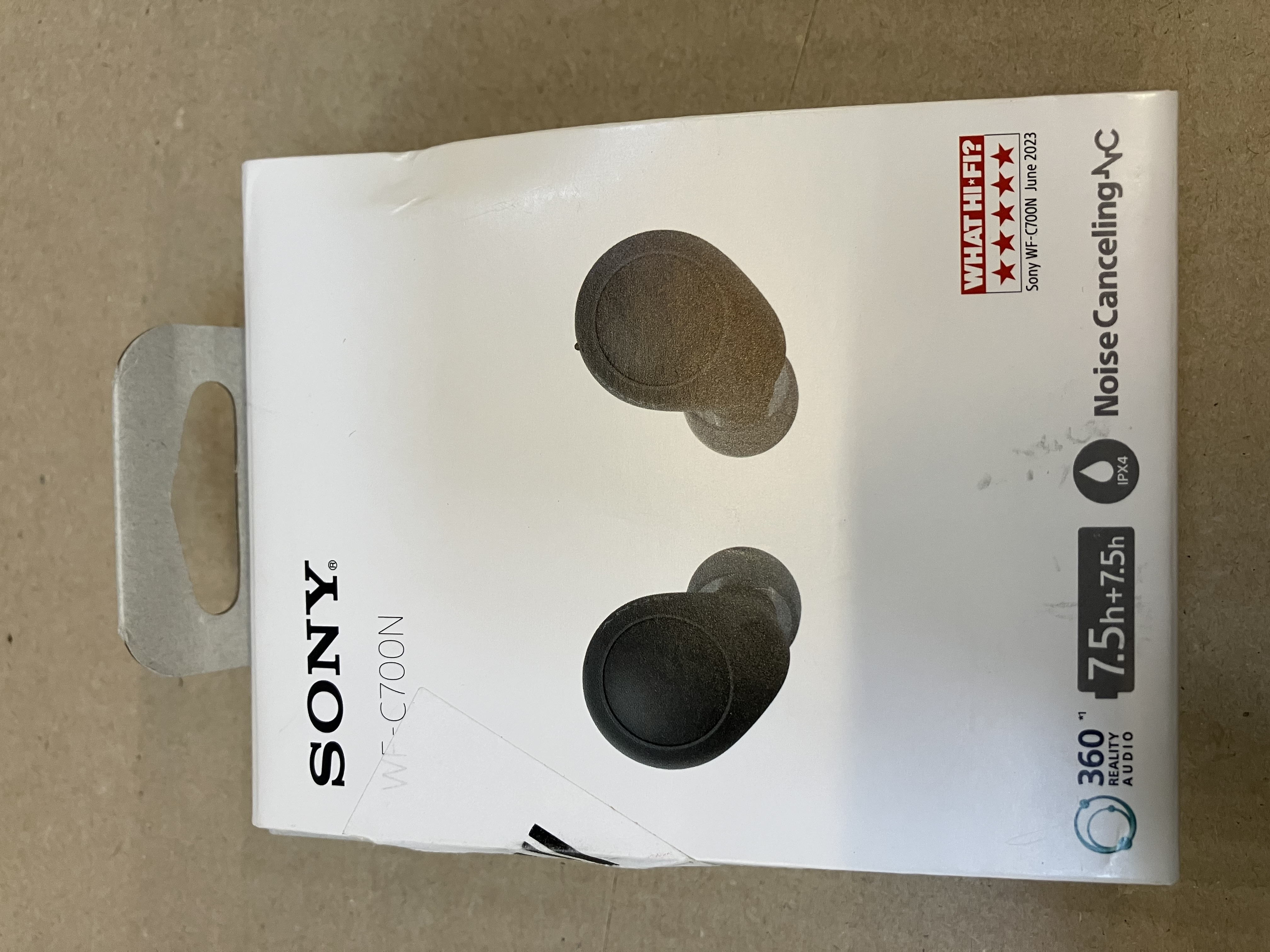 Białe pudełko słuchawek Sony WF-C700N. Pudełko pokazuje słuchawki i tekst.