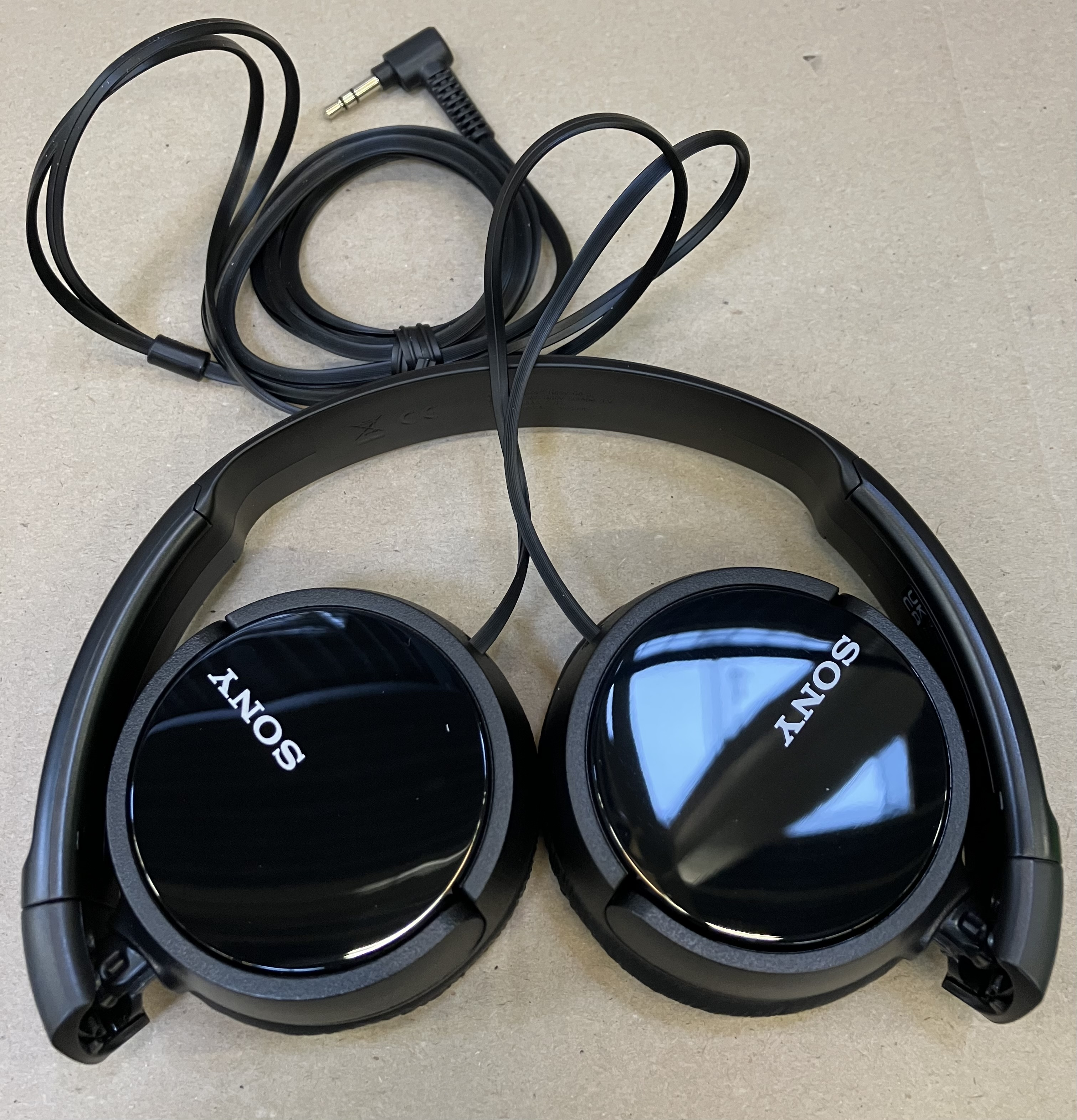 Czarne słuchawki Sony z czarnym kablem i wtyczką 3,5 mm.