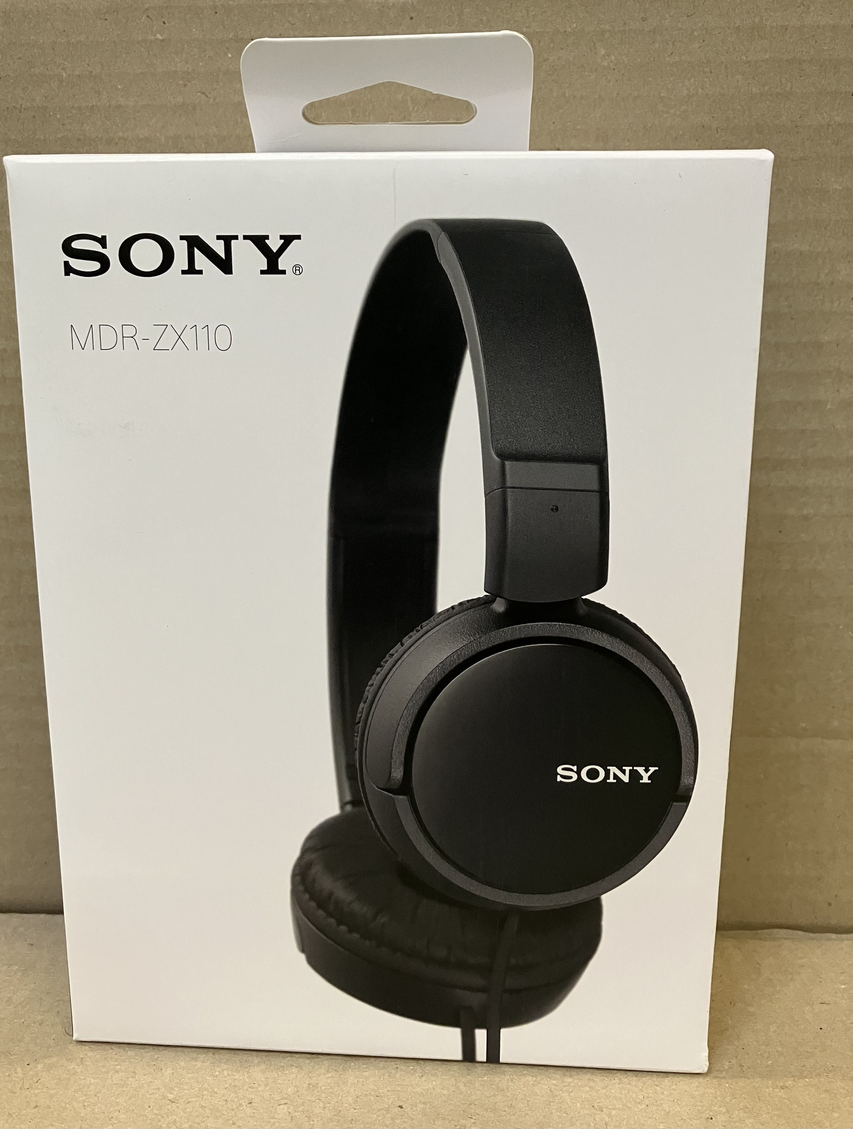 Słuchawki w pudełku. Słuchawki są czarne i mają logo SONY.