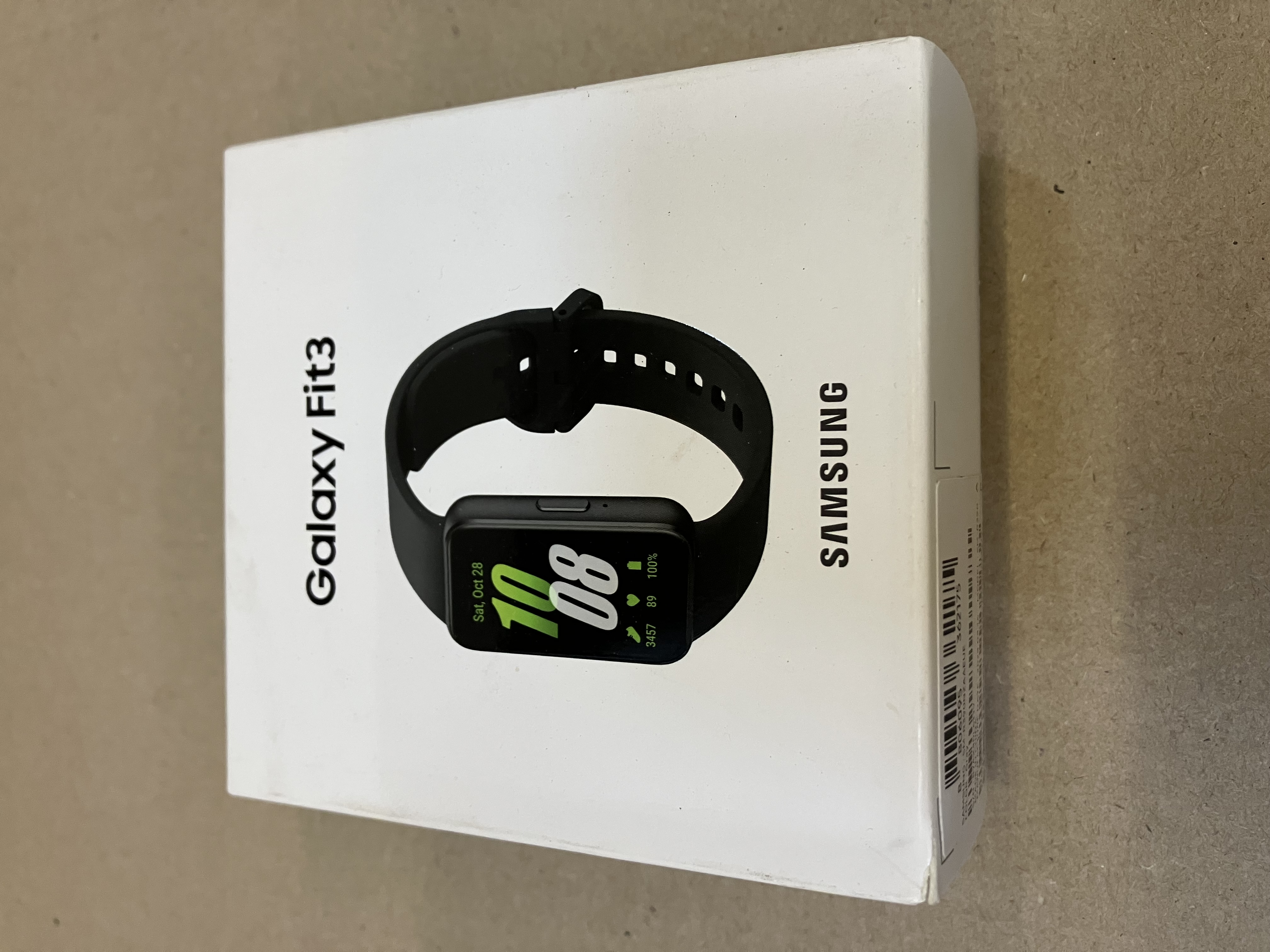 Czarny smartwatch z odłączoną ramką i czarnym paskiem na czarnym tle.