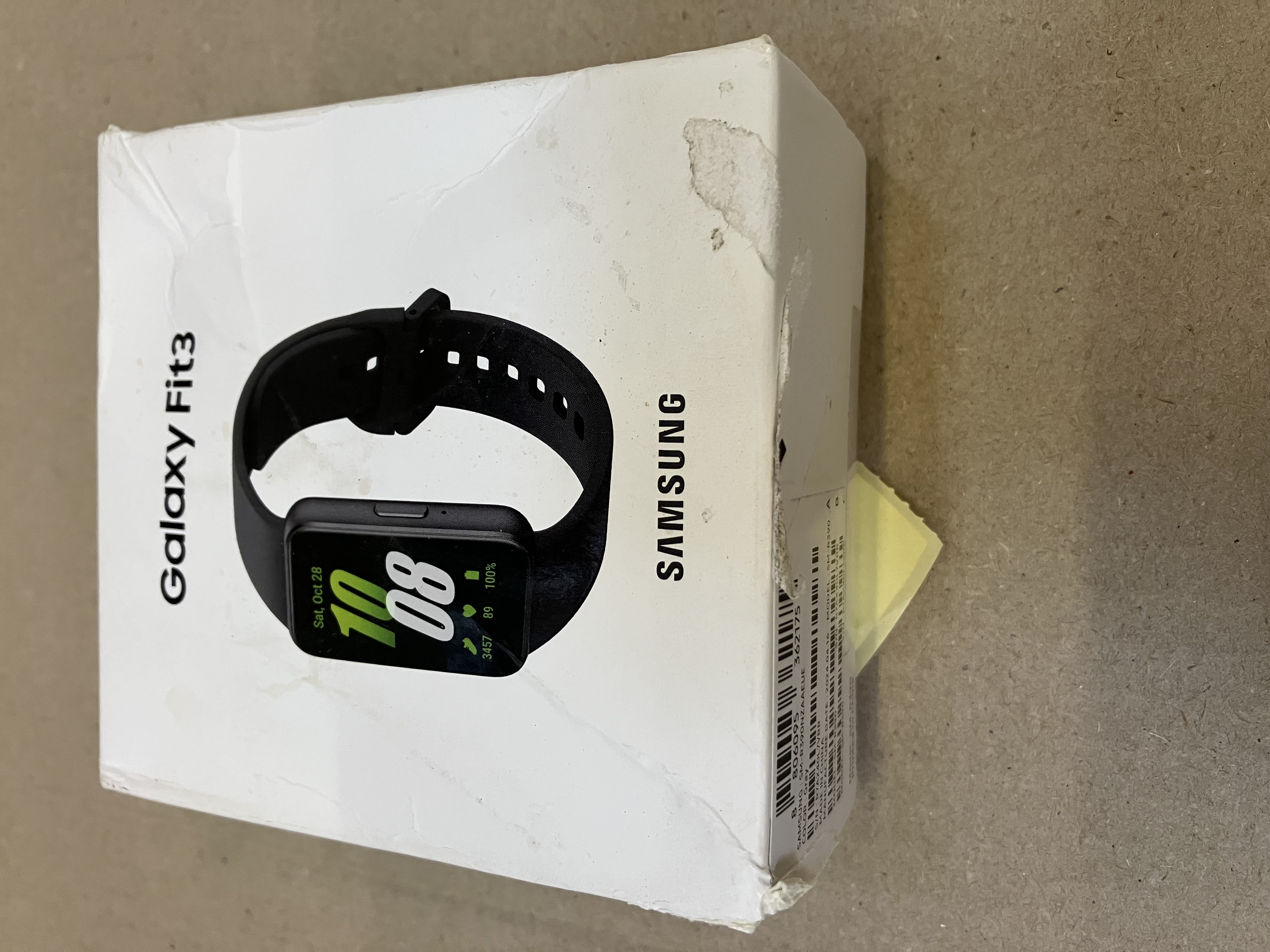Pudełko Samsung Galaxy Fit3 na powierzchni. Zegarek jest widoczny.