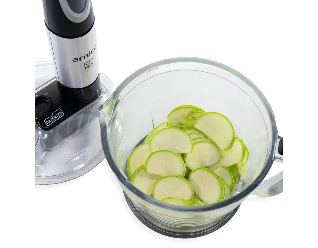 Cam bir kasede kabak dilimleri ile bir blender. Beyaz zemin.