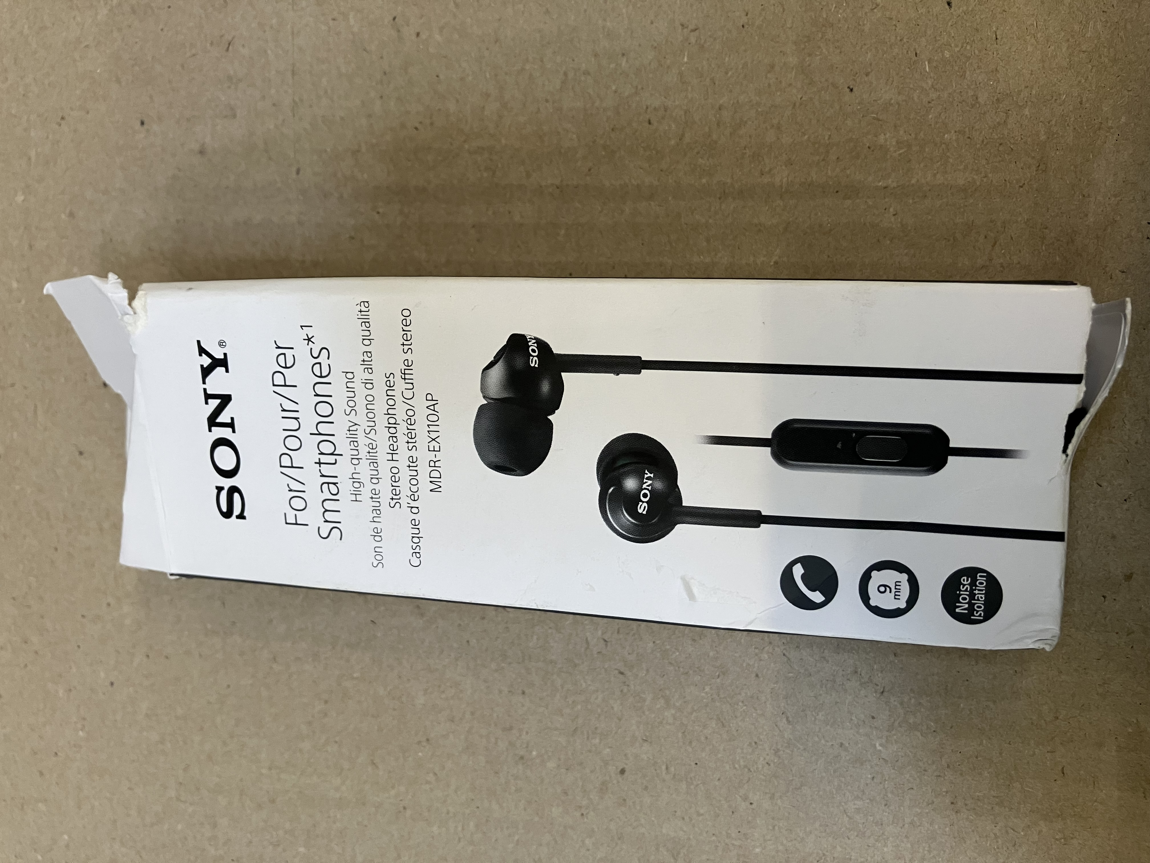 Pudełko słuchawek Sony, otwarte, ze słuchawkami w środku, na powierzchni.