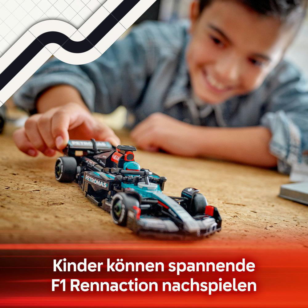 Ein Junge lächelt, während er ein schwarz-blaues Spielzeug-Rennauto baut.