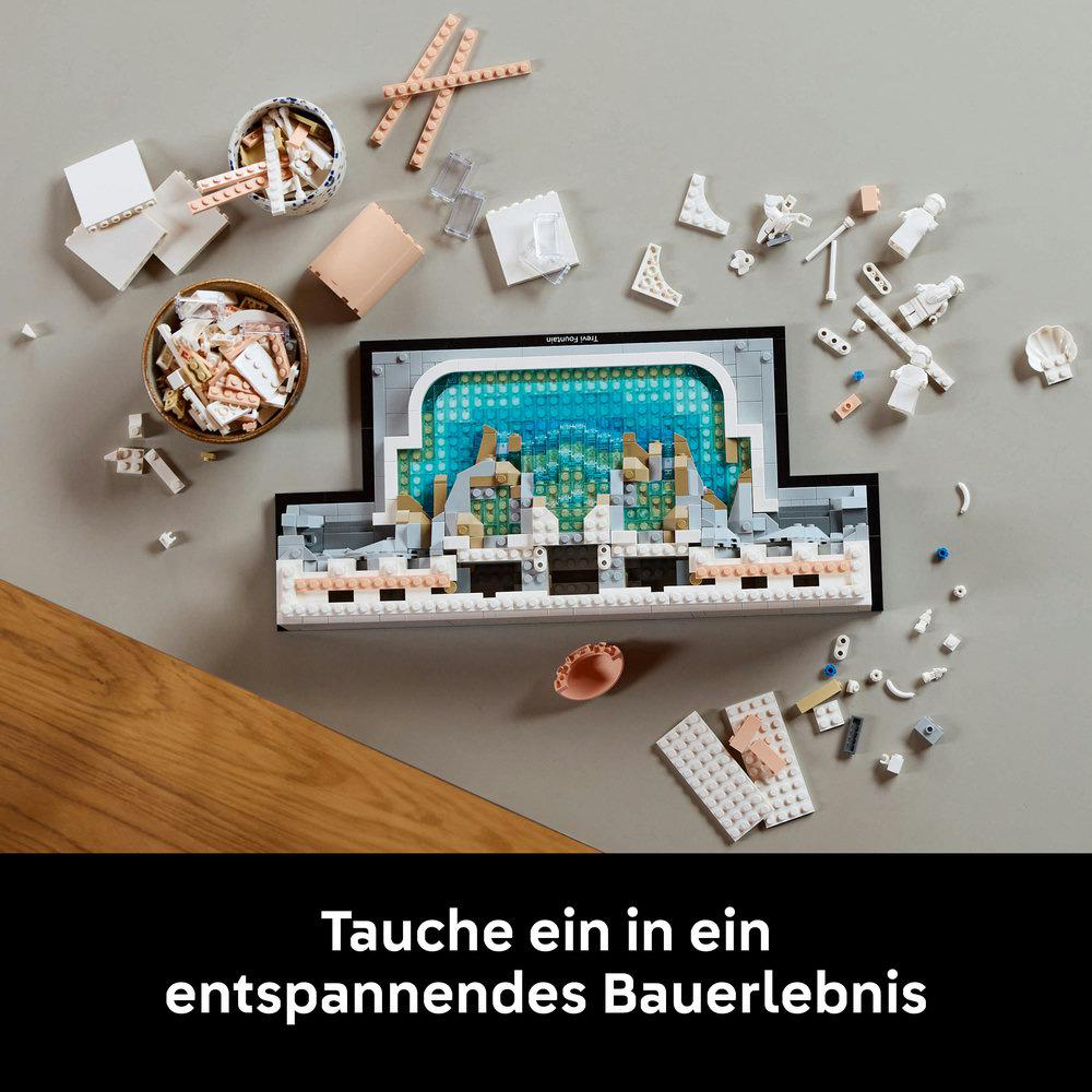 Lego-Set mit einem Brunnen in der Mitte, umgeben von Legosteinen und Anleitungen.