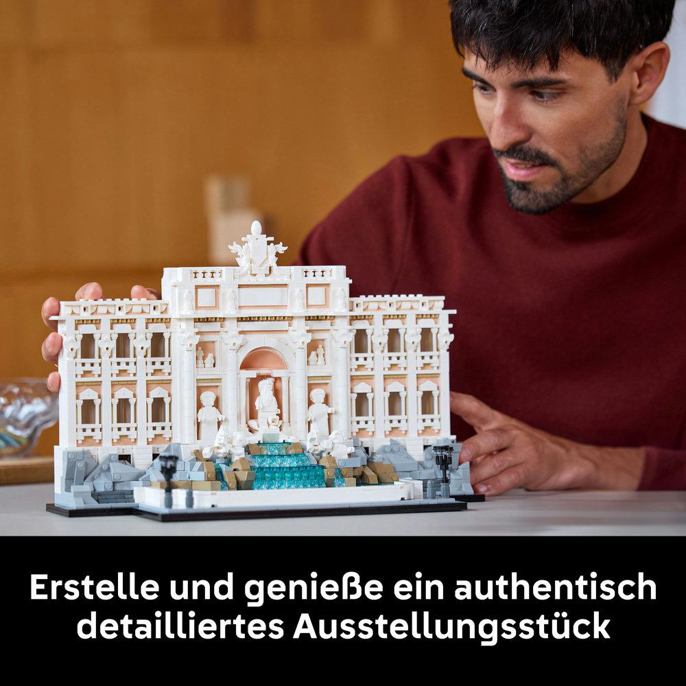Ein Mann betrachtet ein LEGO-Modell des Trevi-Brunnens. Das Modell ist detailliert und beige und weiß.
