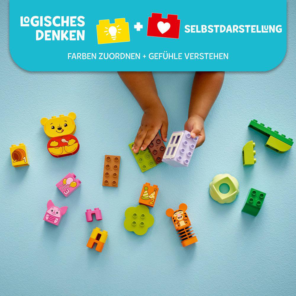 Die Hand einer Person spielt mit bunten Blöcken auf einer blauen Oberfläche.