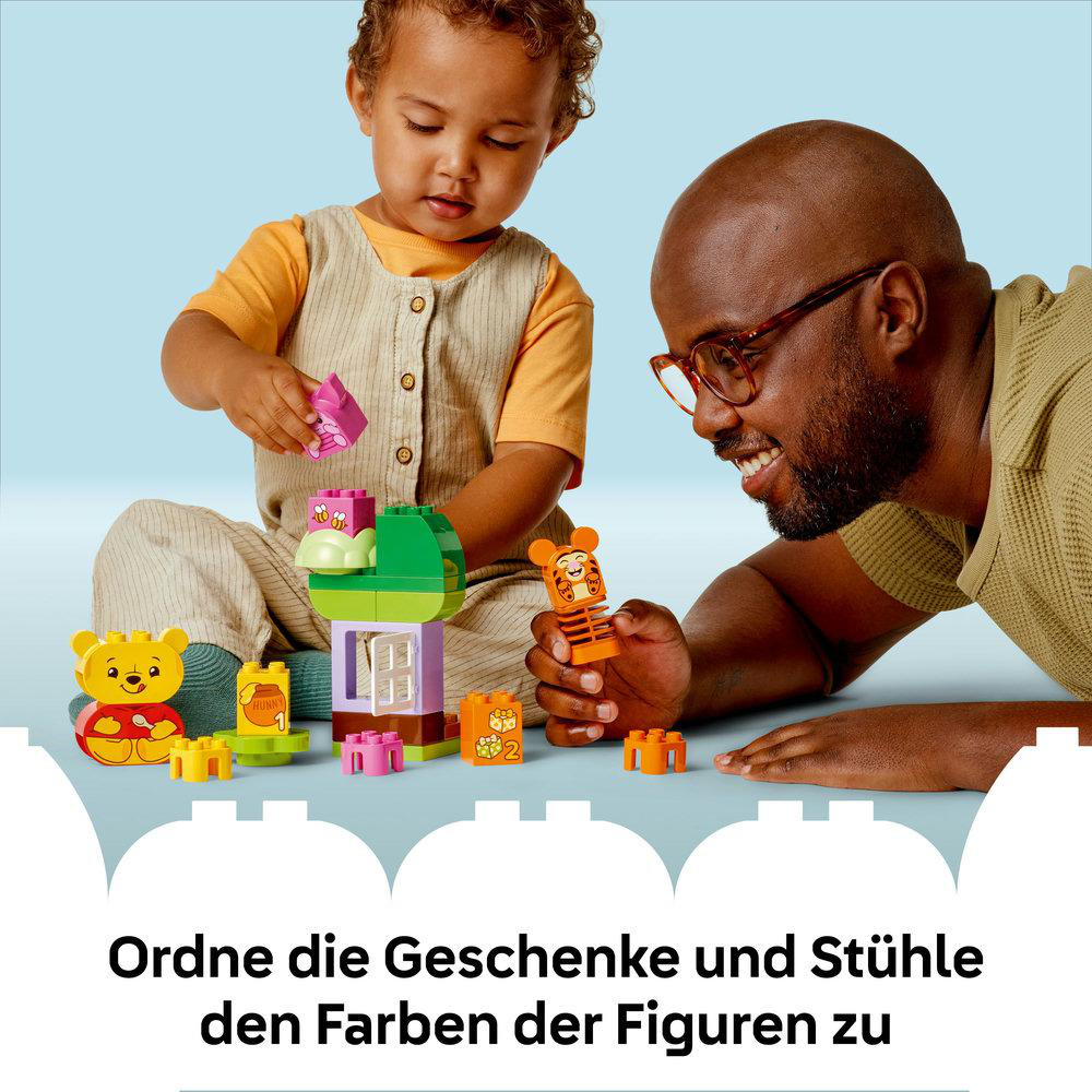 Zwei Personen spielen mit Lego-Spielzeug, ein Kind und ein Erwachsener.