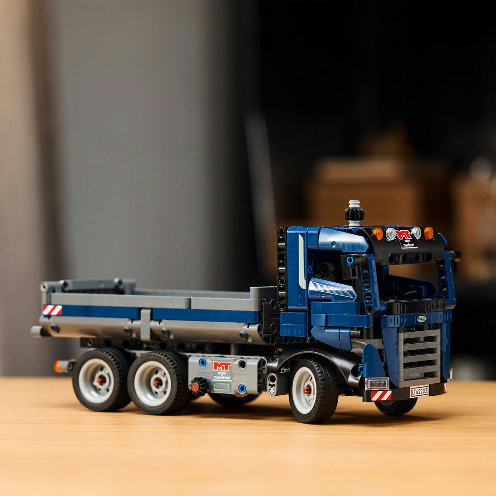 Ein blau-graues Lego-Truck-Modell auf einer Holzoberfläche. Der Hintergrund ist unscharf.