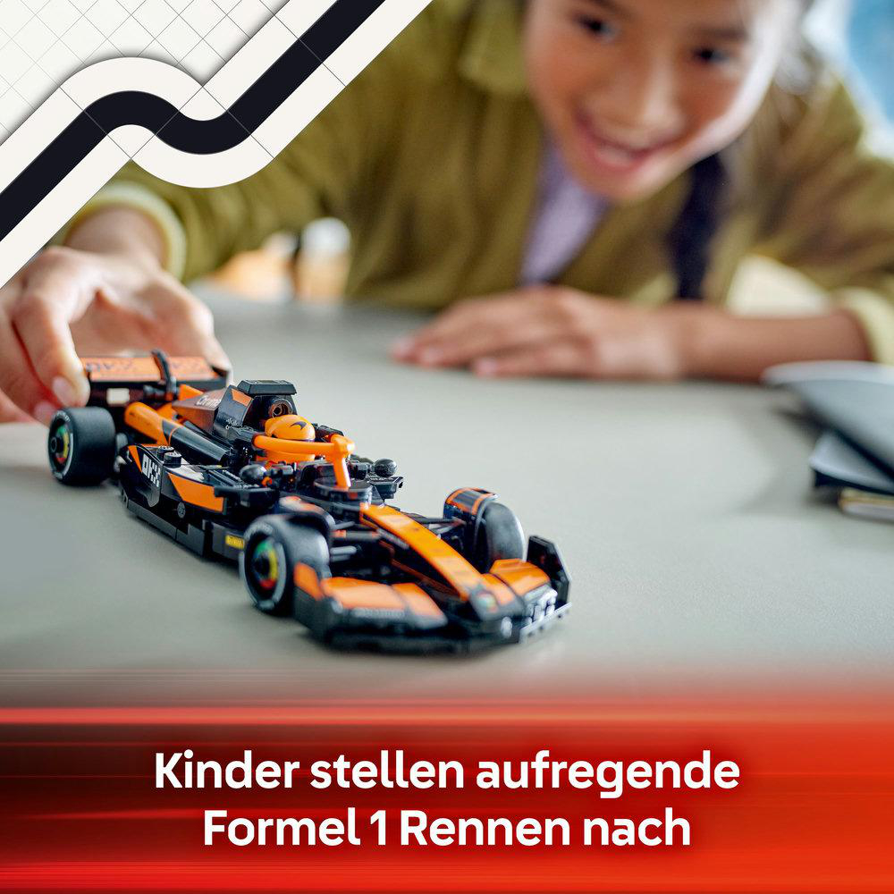 Ein Kind spielt mit einem orangefarbenen und schwarzen Formel-1-Rennwagen-LEGO-Modell auf einem Tisch.