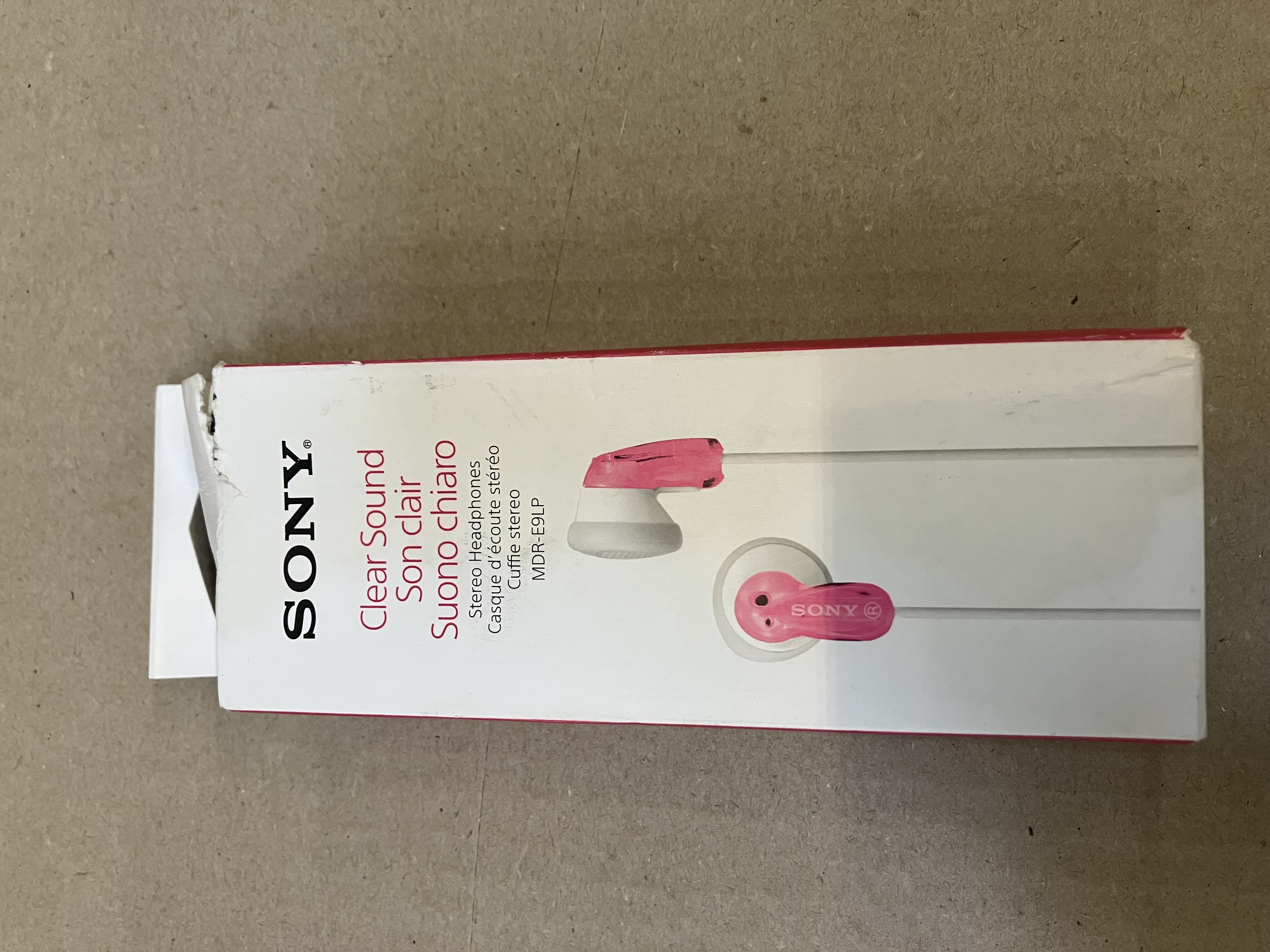 Otwarty karton słuchawek Sony. Słuchawki są różowe.