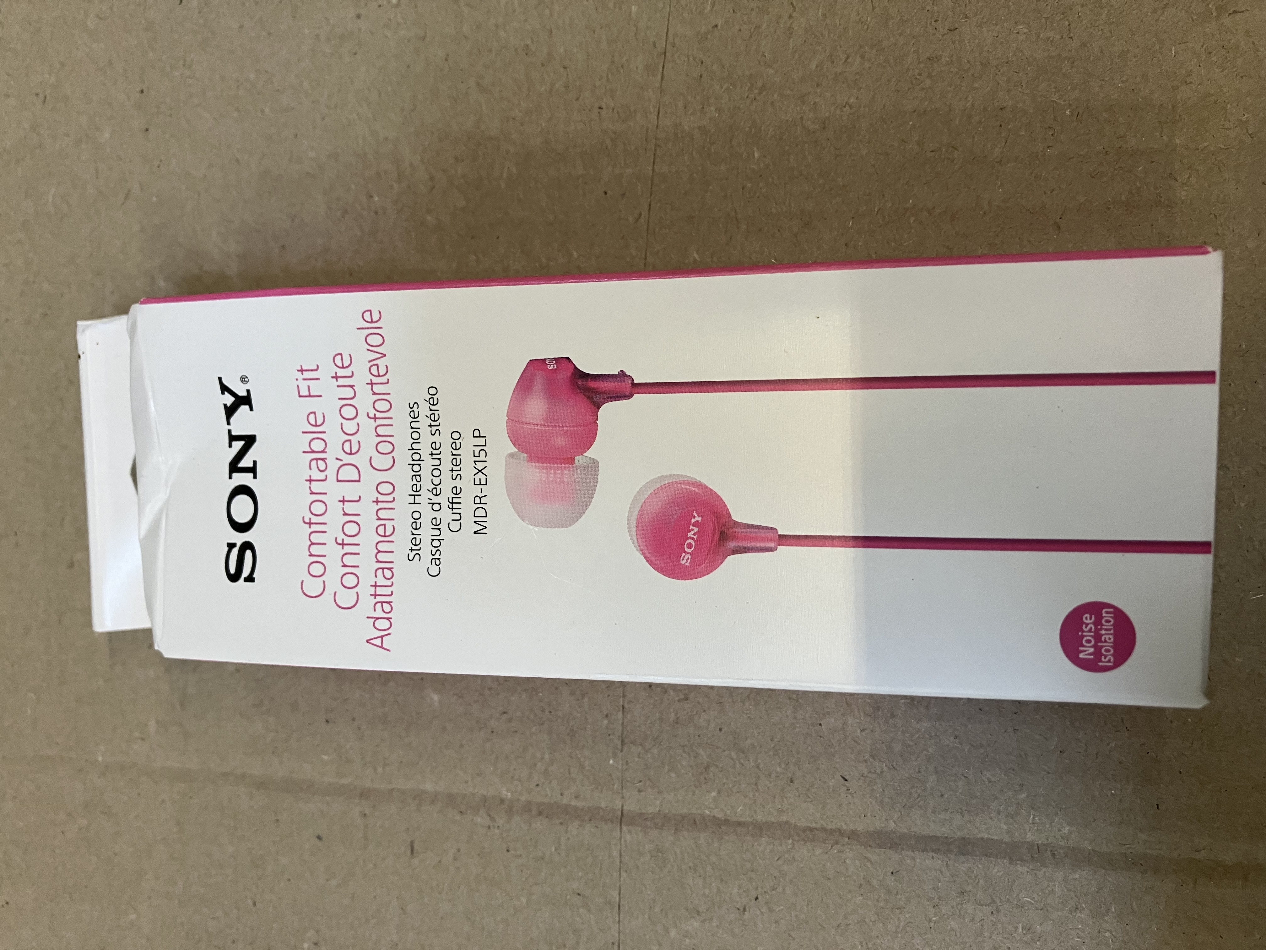 Różowe słuchawki Sony w białym pudełku. Tekst zawiera 'Comfortable Fit' i 'Noise Solution'.
