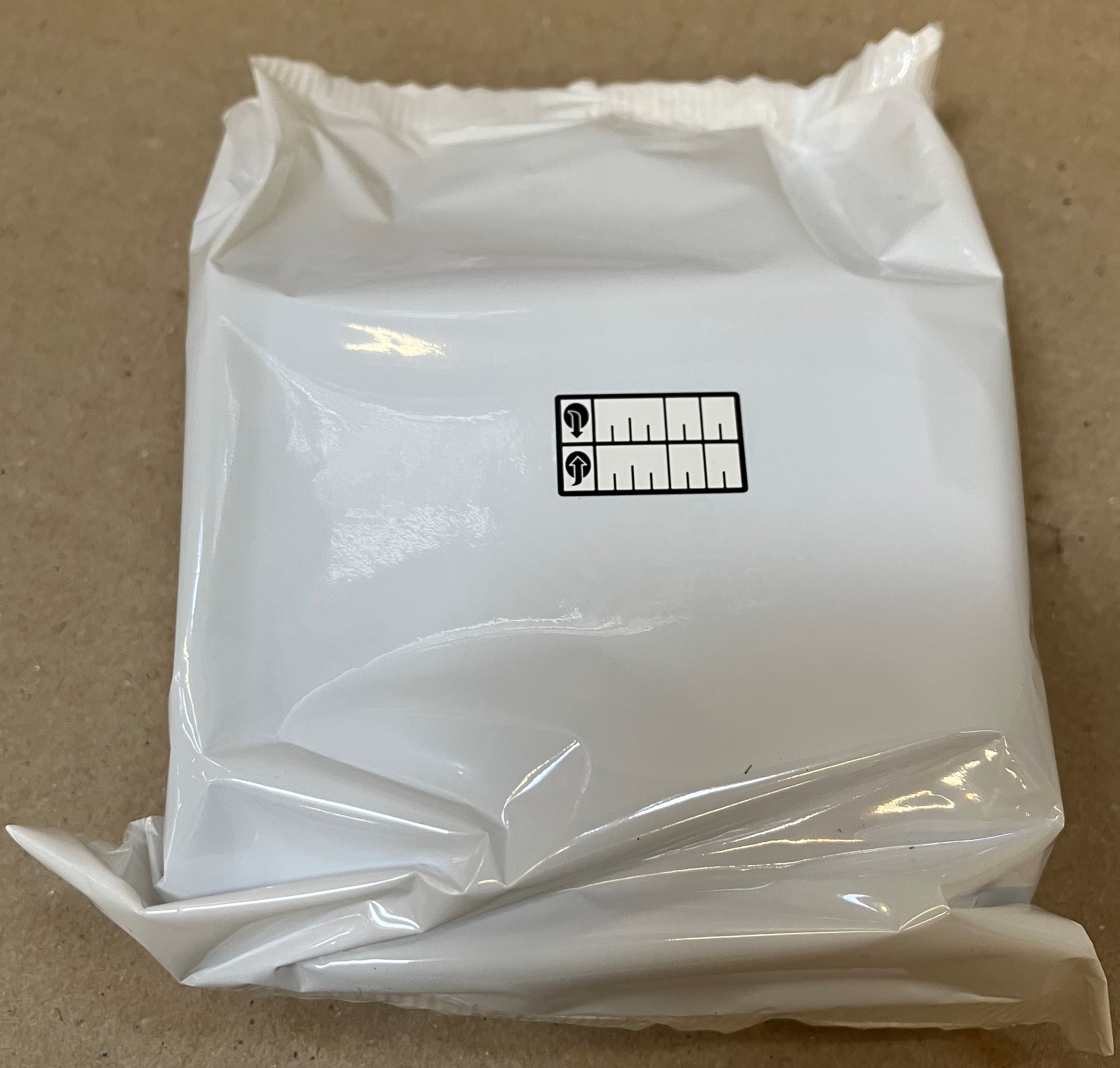 Biała plastikowa torba z czarno-białą naklejką.