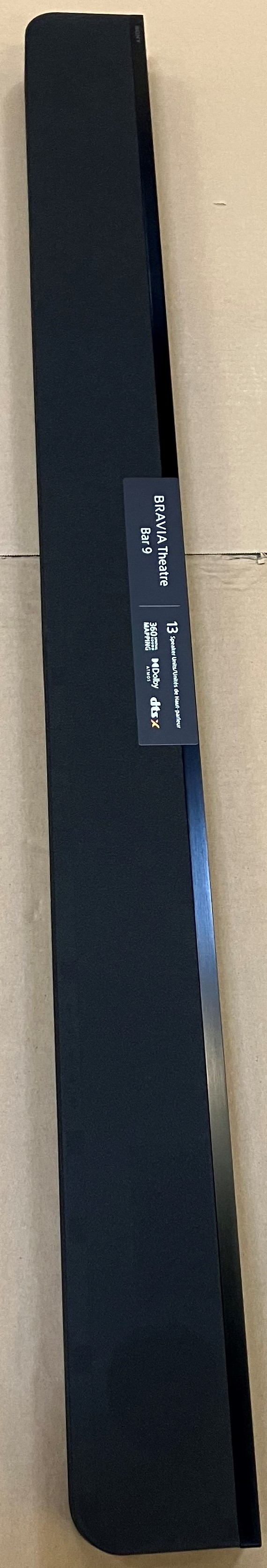 Czarny soundbar z naklejką. Białe tło.