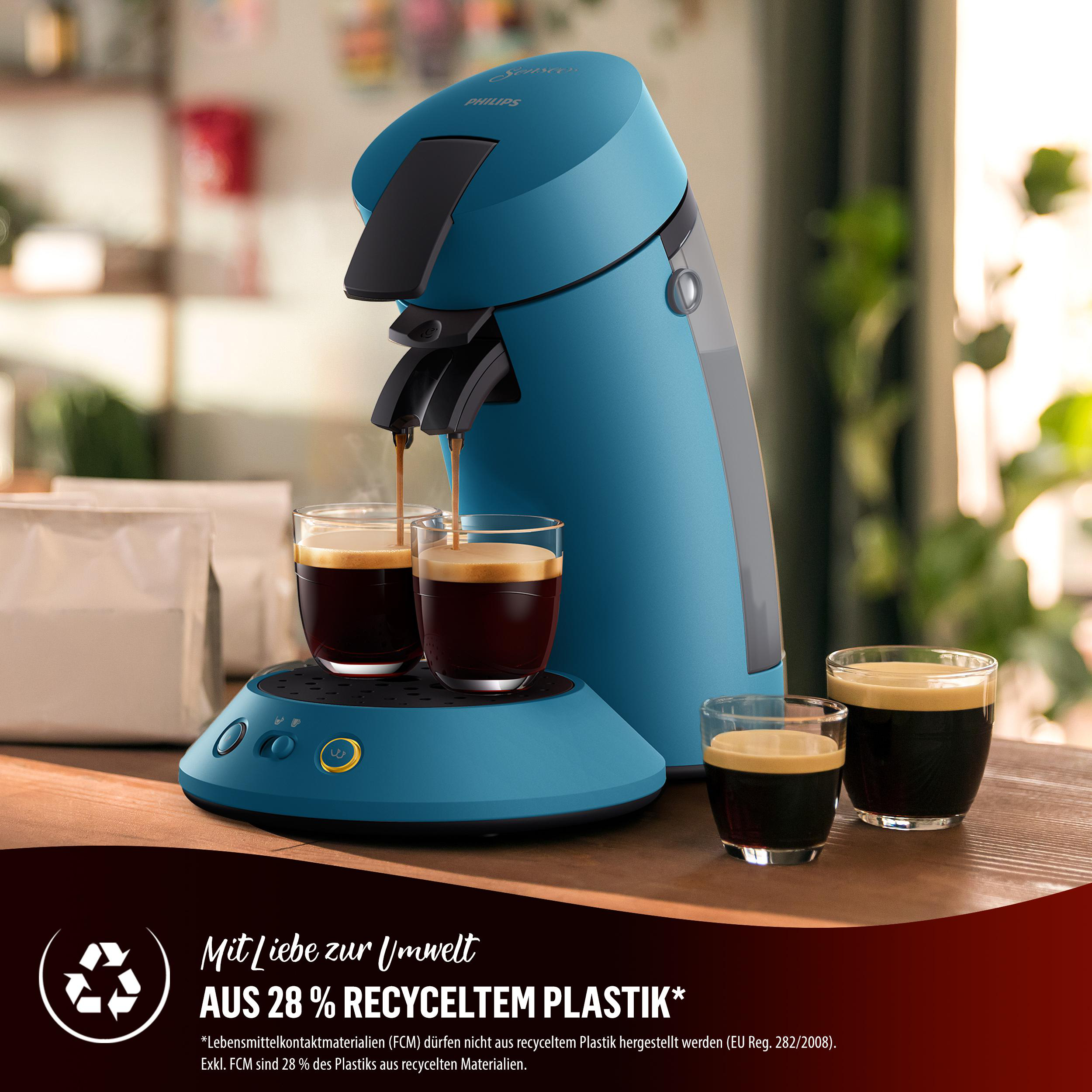 Eine türkisfarbene Philips Senseo Kaffeemaschine mit zwei Gläsern Kaffee, die eingefüllt werden. Text unten.