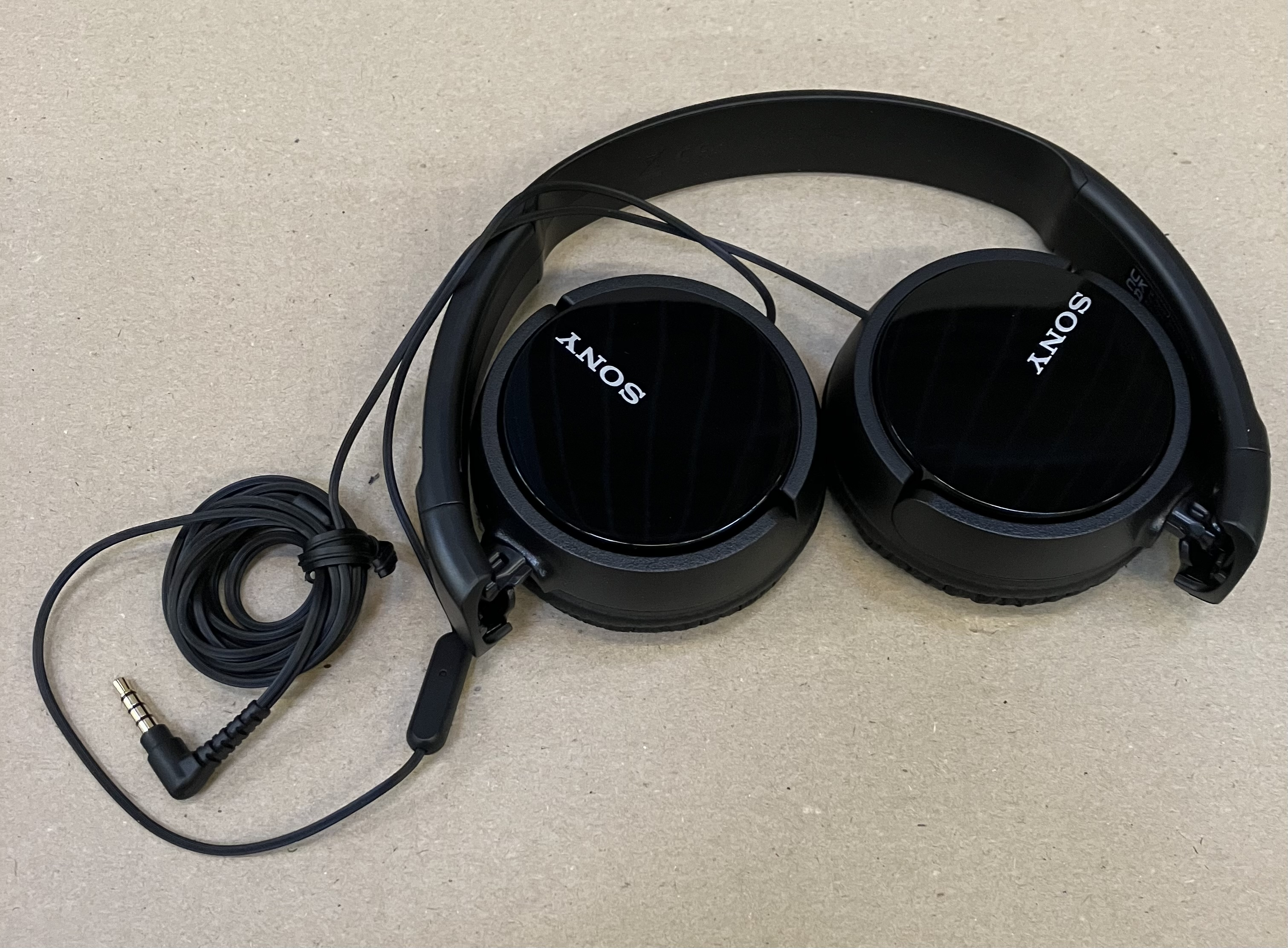 Czarne słuchawki Sony z kablem i wtyczką na powierzchni.