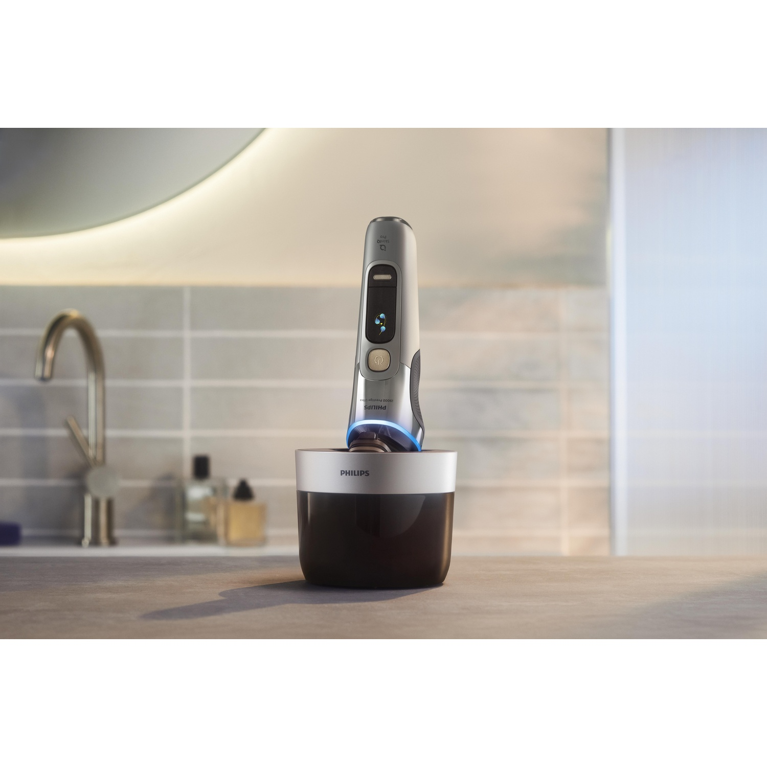 A silver and black electric shaver in a black charging base, on a countertop.