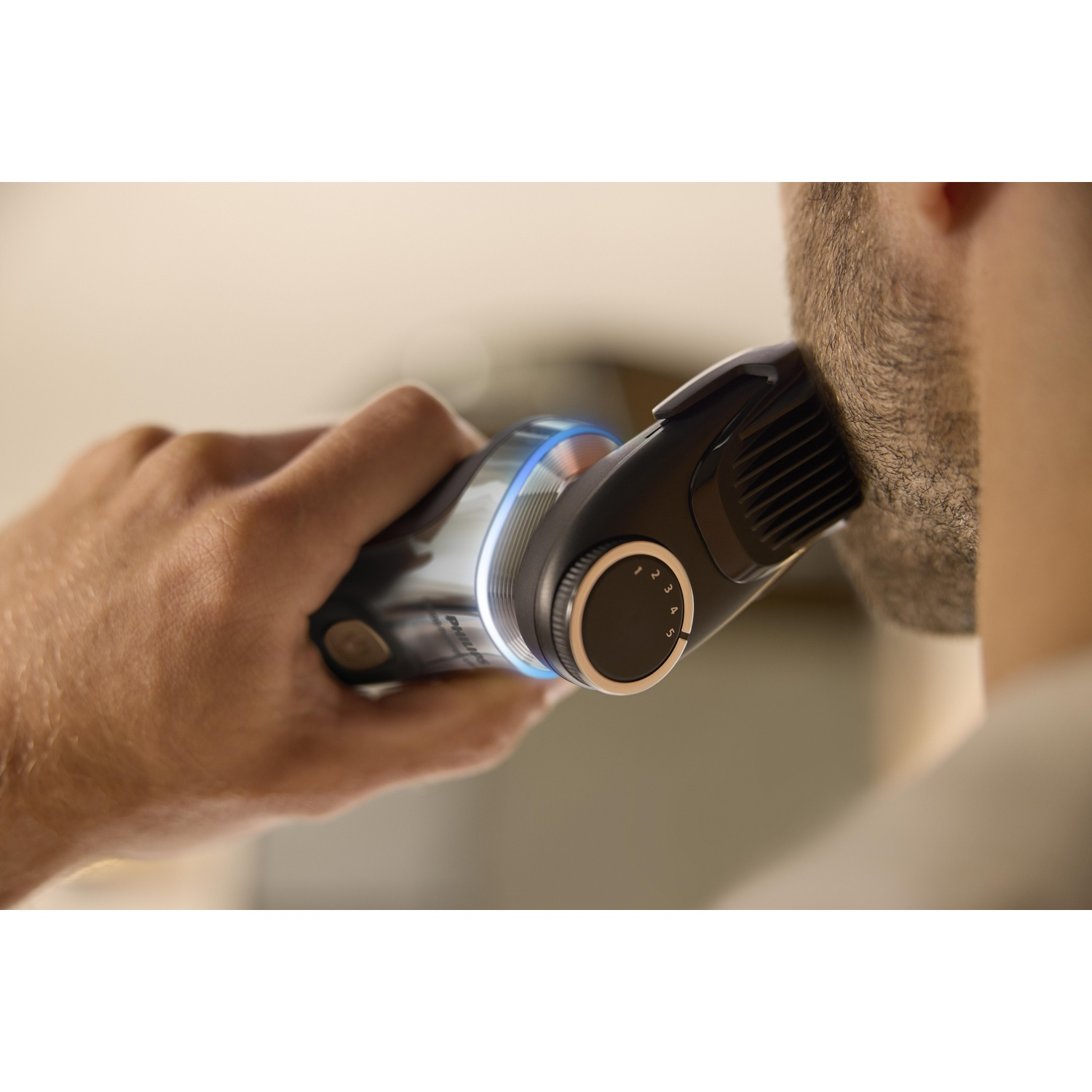 A man trimming his beard with an electric trimmer.