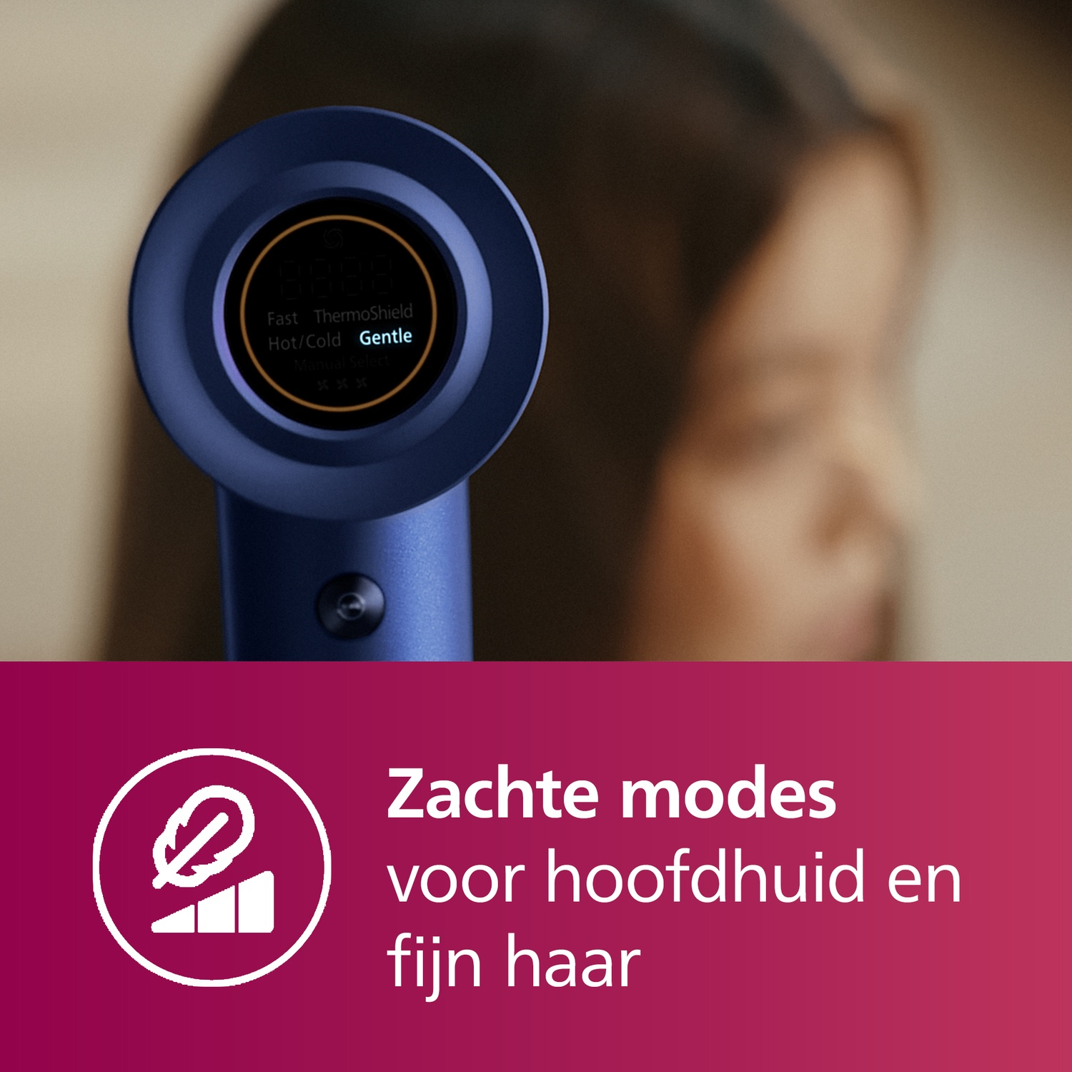 Hair dryer with a blue handle and a screen showing the settings. The background is blurred.