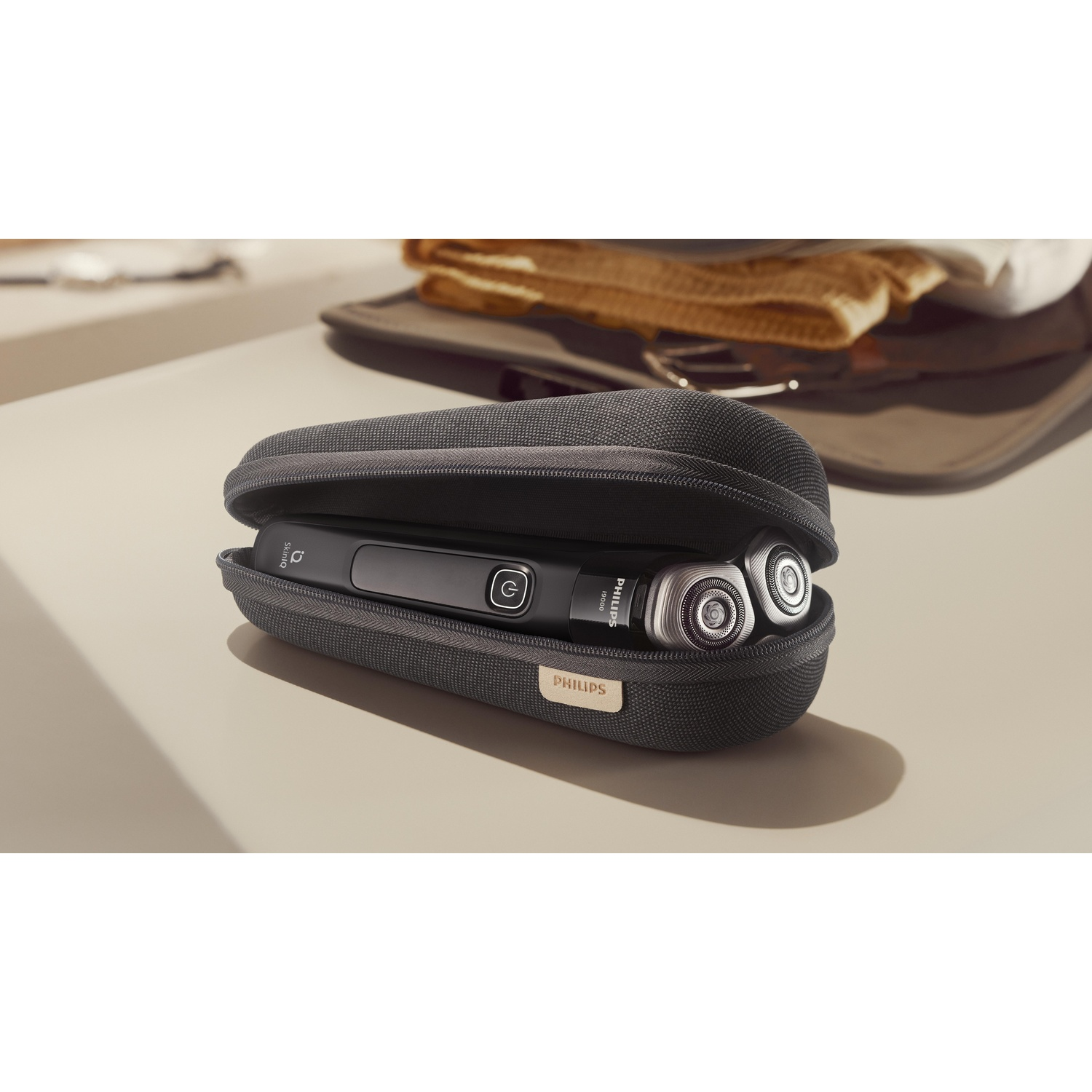 Zwart Philips elektrisch scheerapparaat en etui. Scheerapparaat open in etui.