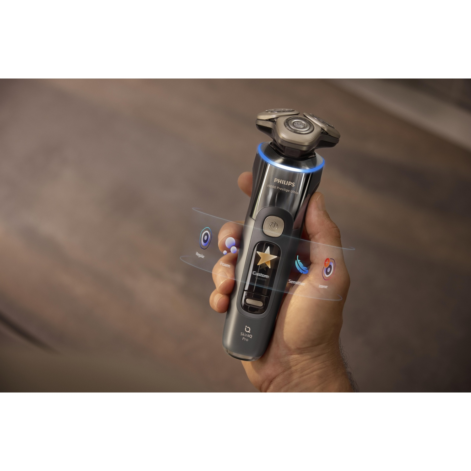 A man's hand holding a Philips shaver with display and controls.