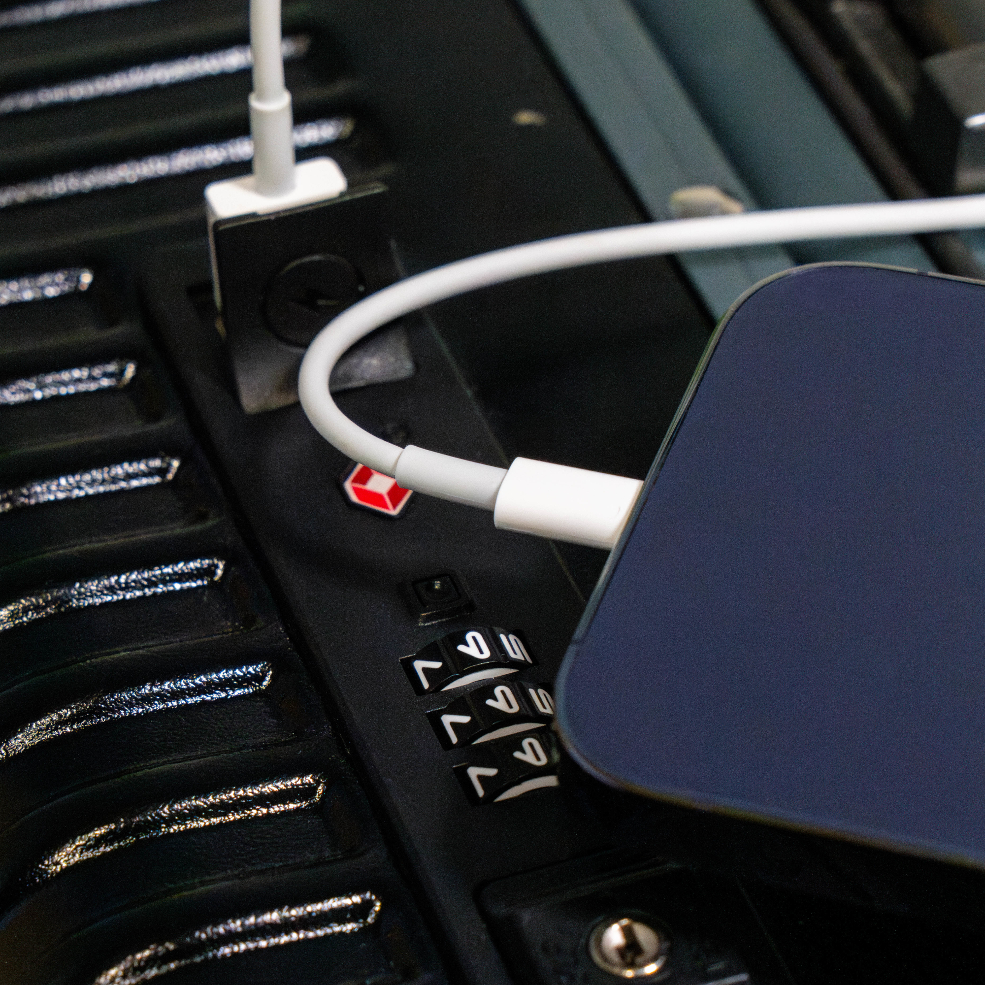 Ein Smartphone, das in einem Fahrzeug geladen wird, mit Schloss und USB-Kabel.