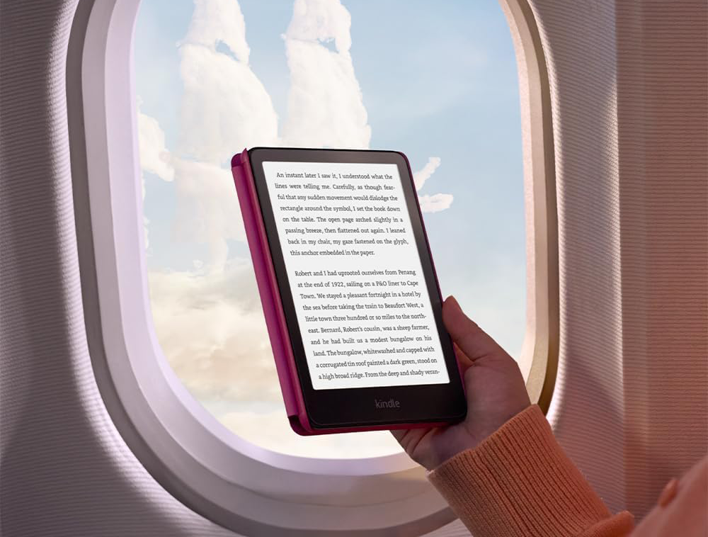 Személy Kindle e-olvasót tart repülőgép ablakánál.