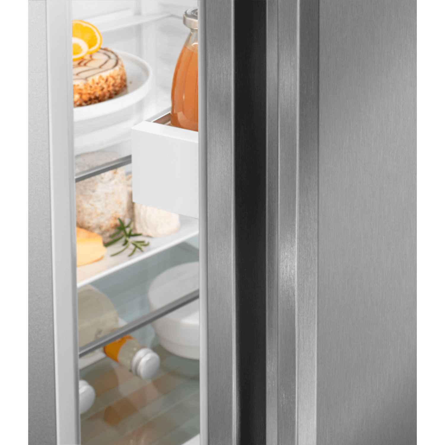 A partially open fridge door shows food items: cake, orange slice, jars, cheese, and a bottle.