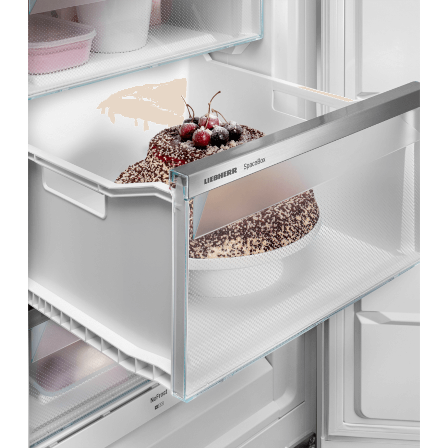 Cake with cherries in a white refrigerator drawer.