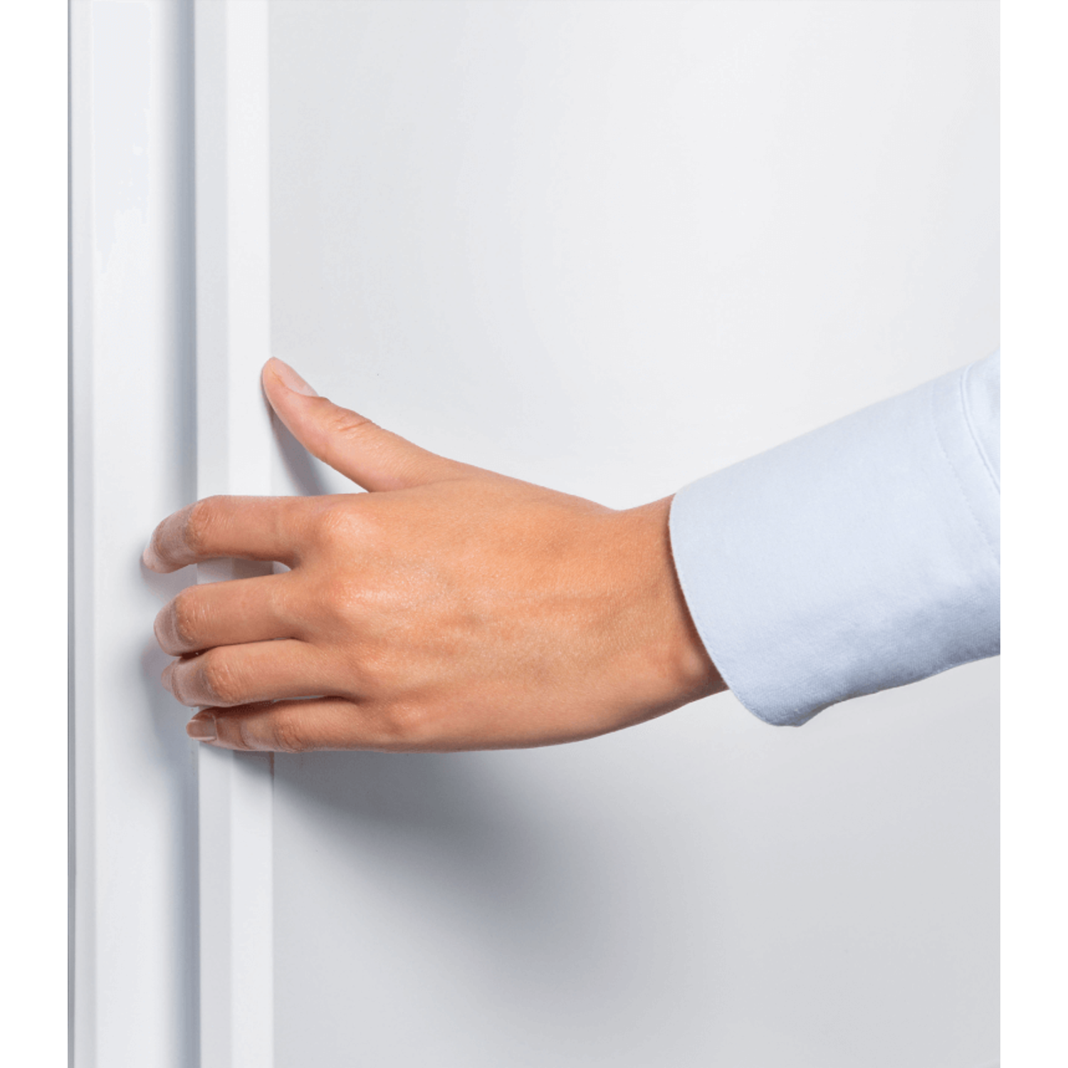 A hand, wearing a light blue shirt, holding a white door.
