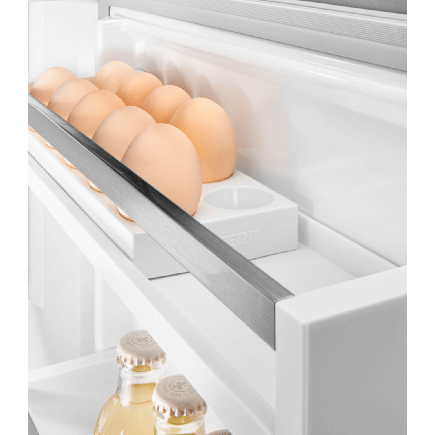 Eggs in a white fridge shelf, next to a metal bar.